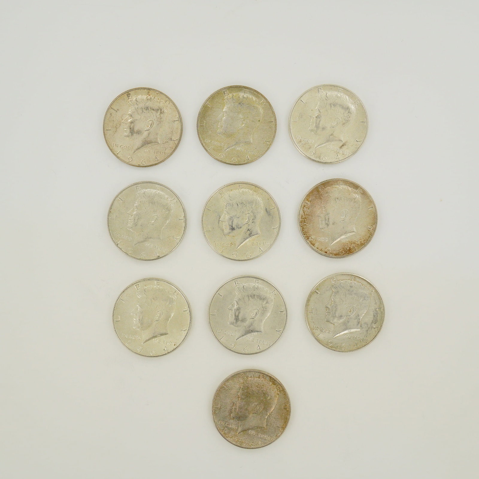 A Collection of Ten 1964 US Kennedy Silver Half Dollars: This collection of ten US Kennedy half dollars, all dated 1964, represents a $5.00 face value. The coins are composed of 90% silver and 10% copper. The lot includes specimens from the Philadelphia min