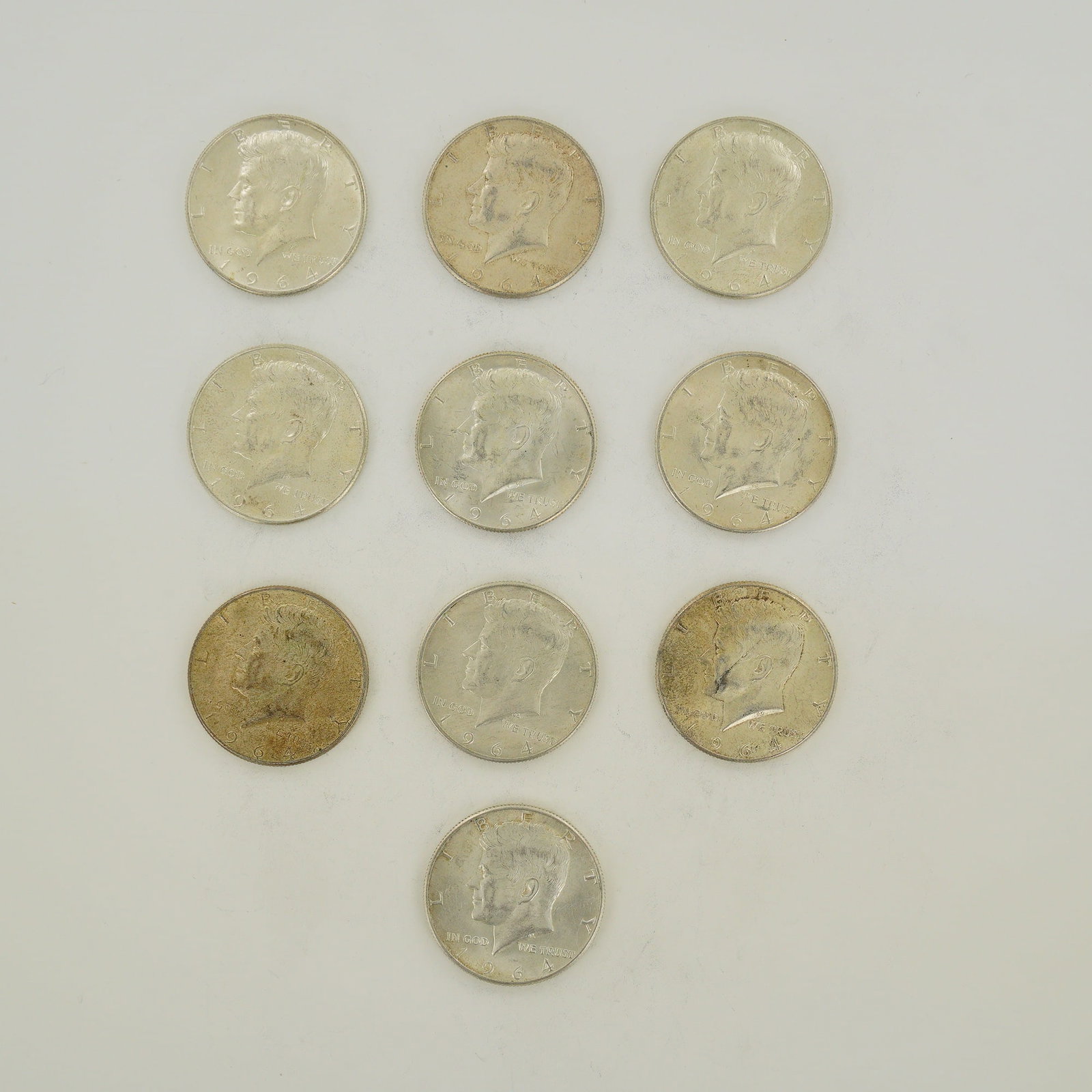 A Collection of Ten US 1964 Kennedy Half Dollars $5.00 Face Value: This lot consists of ten US 1964 Kennedy half-dollar coins representing a $5.00 face value. Struck in .900 fine silver, these coins feature the Kennedy obverse and the modified Presidential Seal rever