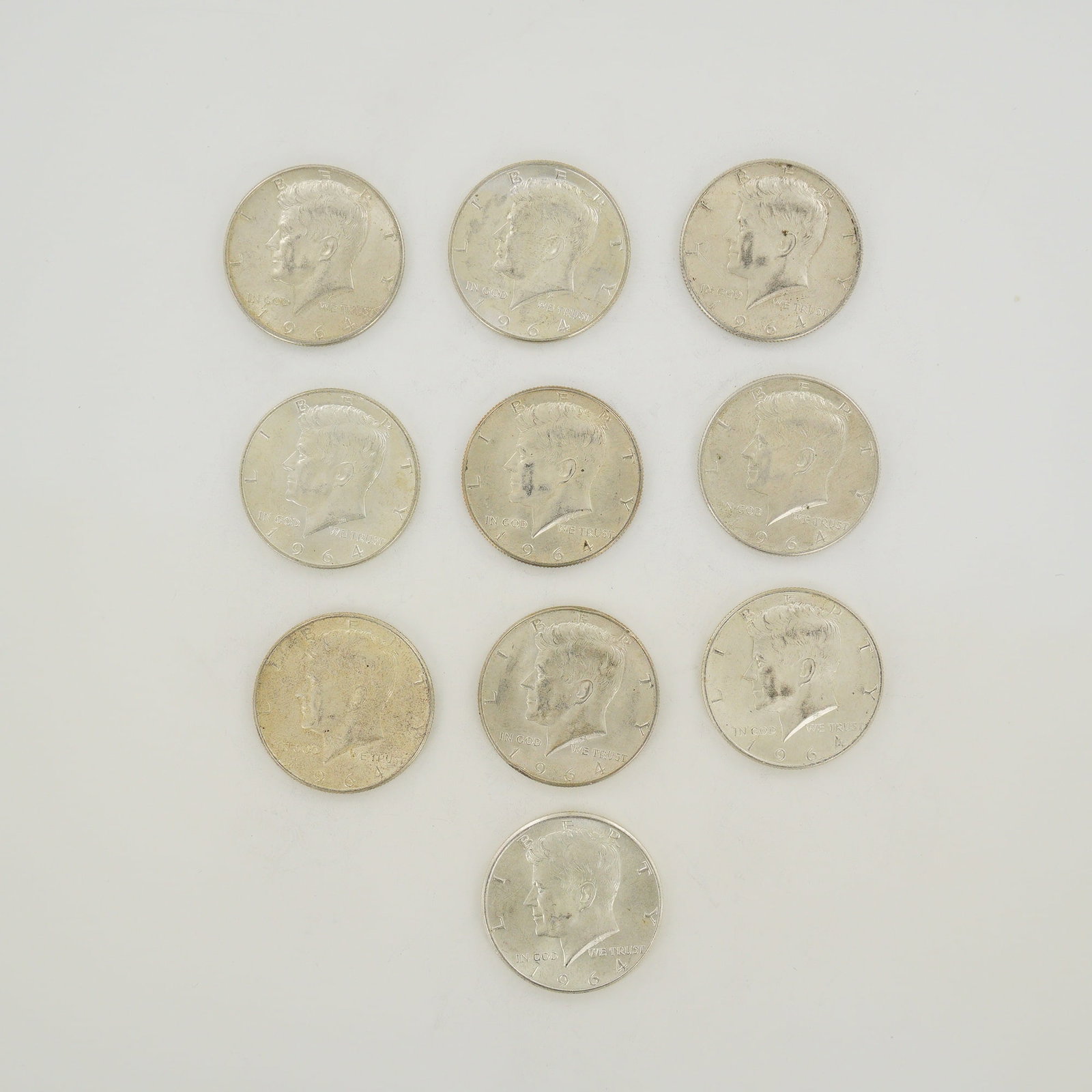A Collection of Ten US 1964 Kennedy Half Dollars $5.00 Face Value: A collection of ten US 1964 Kennedy Half Dollars representing a total $5.00 face value. These coins are struck in 90 percent silver with a fineness of 0.900. The group includes specimens featuring the