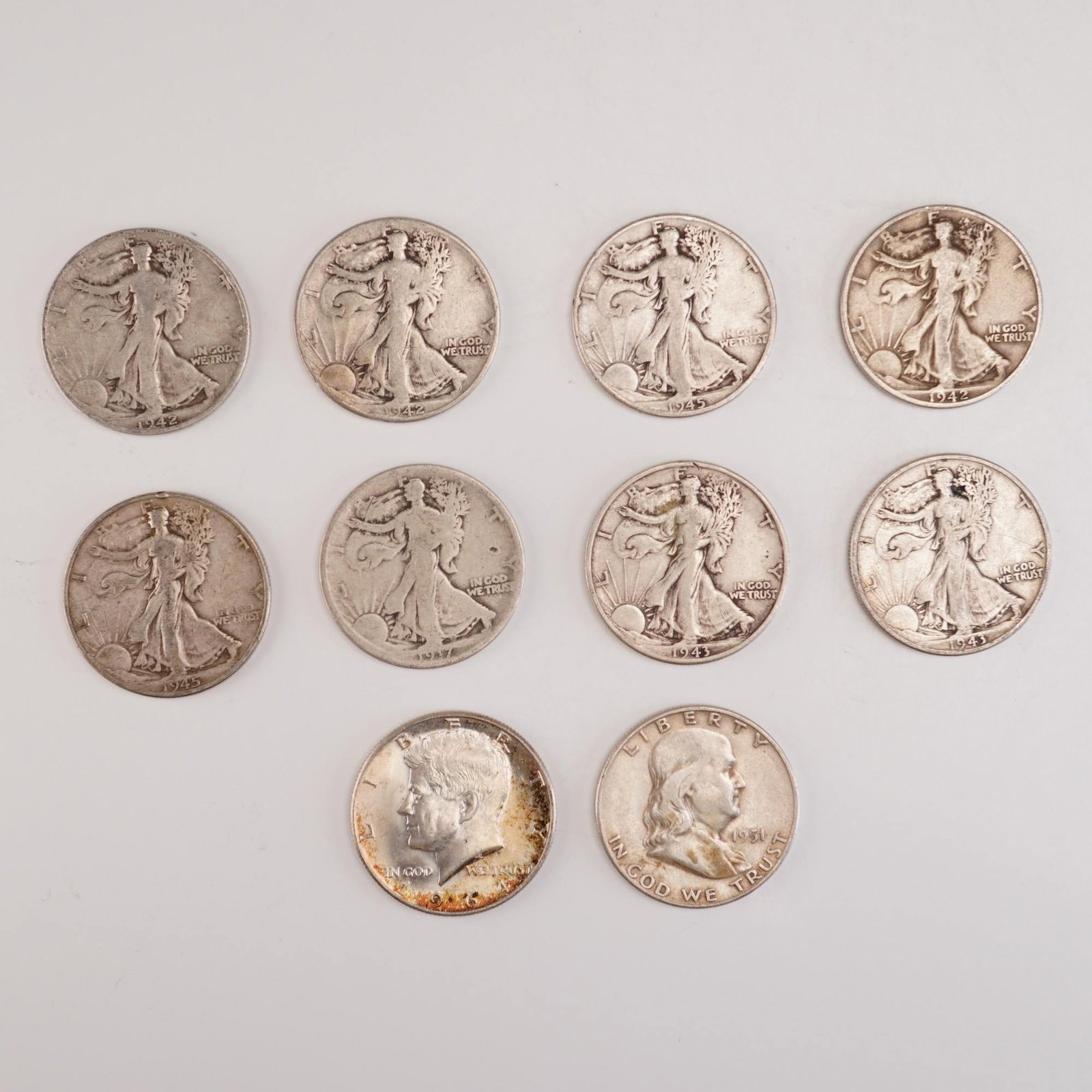 10pc Pre-1964 U.S. Franklin, Kennedy, and Walking Liberty Half Dollar Coins: This collection includes a 1951 Franklin Half Dollar composed of 90% silver and 10% copper, featuring Benjamin Franklin on the obverse and the Liberty Bell on the reverse; a 1964 John F. Kennedy Half 