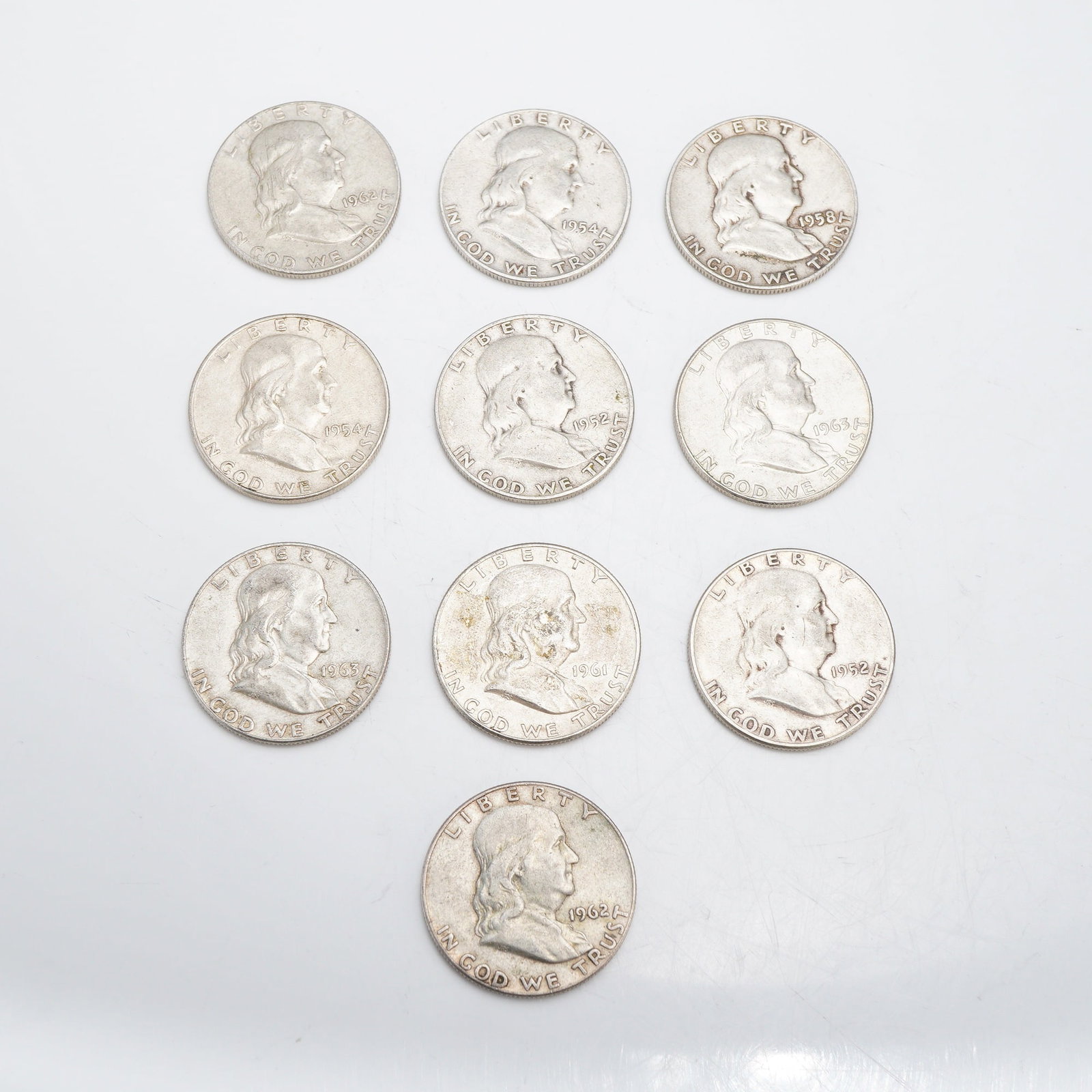 A Group of US Franklin Half Dollars, $5.00 Face Value: This group of US Franklin half dollars represents a $5.00 face value. Struck in 90% silver (.900 fine) and 10% copper, the collection includes coins dated 1952, 1954, 1958, 1961, 1962, and 1963. Sever