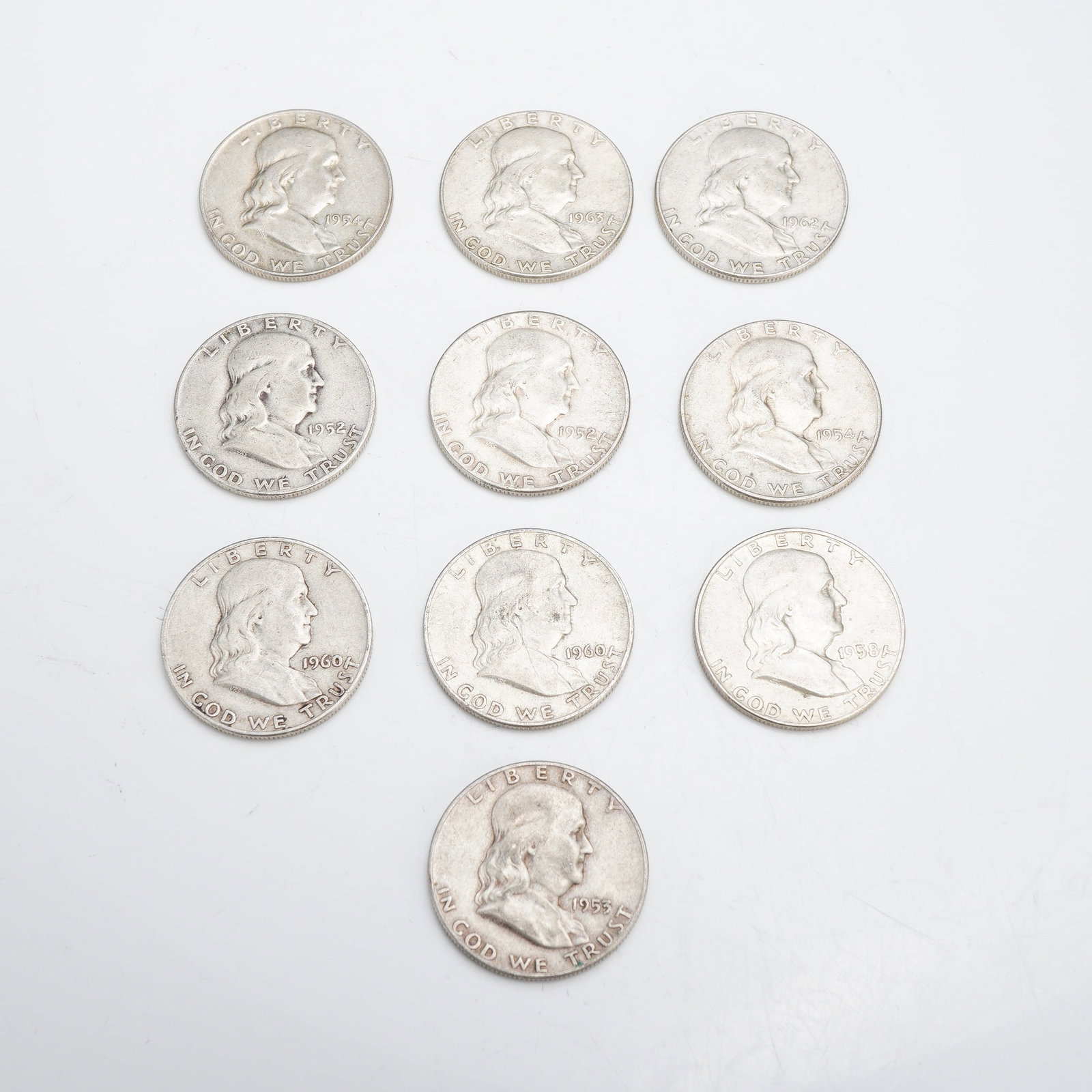 A Collection of 10 US Franklin Half Dollars, $5.00 Face Value: A collection of ten US Franklin half dollars with a total $5.00 face value. The group includes two 1952-D, one 1953-D, one 1954-D, one 1954-S, one 1958-D, two 1960-D, one 1962-D, and one 1963 Philadel
