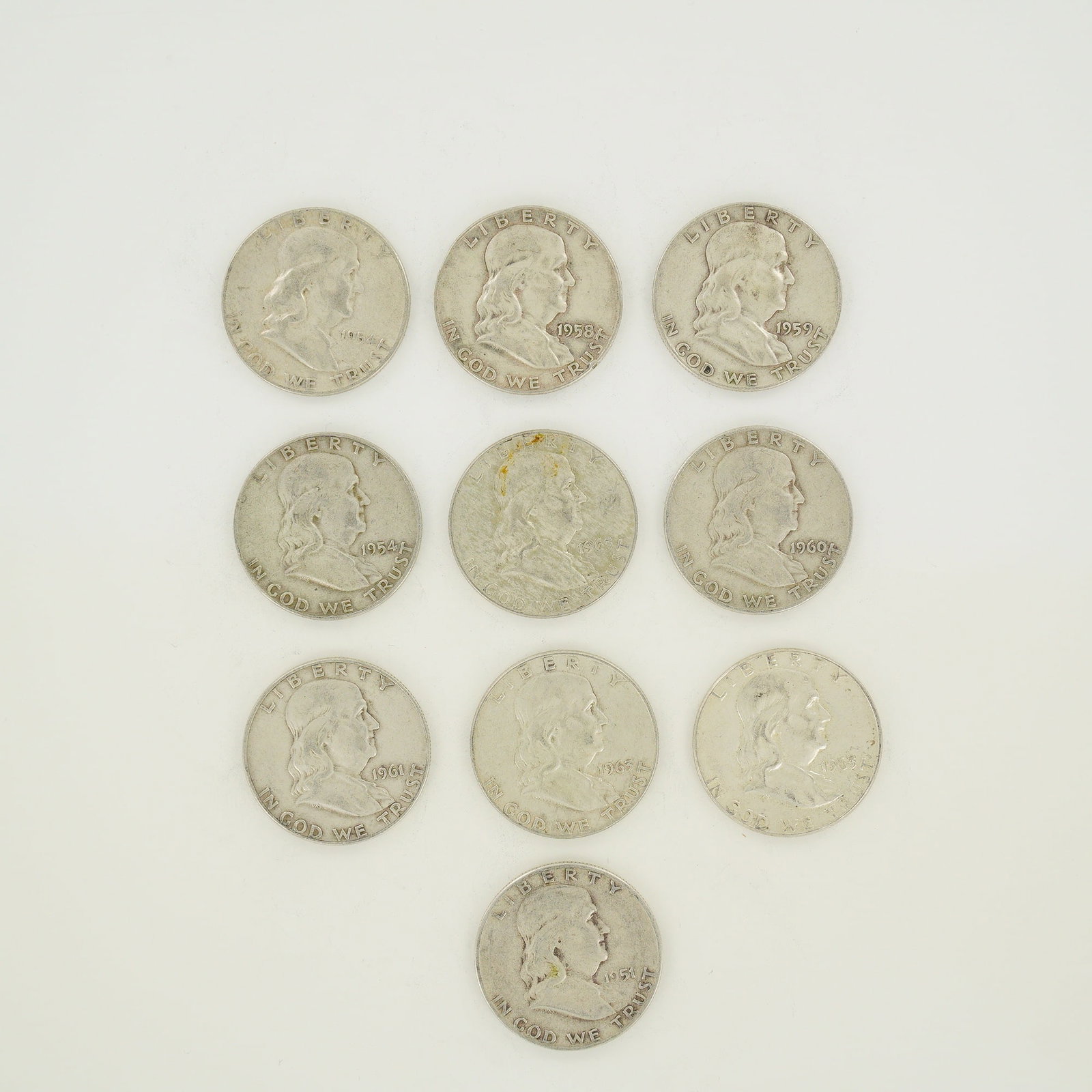 A Collection of Ten US Franklin Half Dollars, 90% Silver, $5.00 Face Value: A collection of ten US Franklin half dollars representing a $5.00 face value. The group includes one 1951-D, two 1954-D, one 1958-D, one 1959-D, one 1960-D, one 1961-D, and three 1963 specimens.