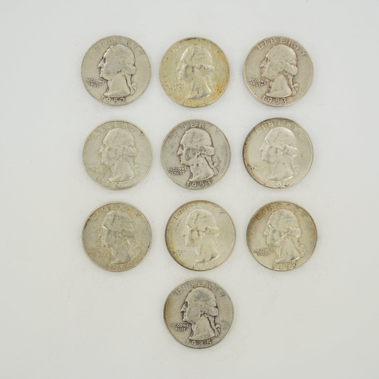 10pc Collection of US Silver Washington Quarter Dollars, 1945-1964: This collection of US Washington Quarter Dollars consists of a mixed date bag of 90% silver coinage. The assortment includes various dates such as 1945, 1952, 1953, 1957, 1962, and 1964. Each coin fea