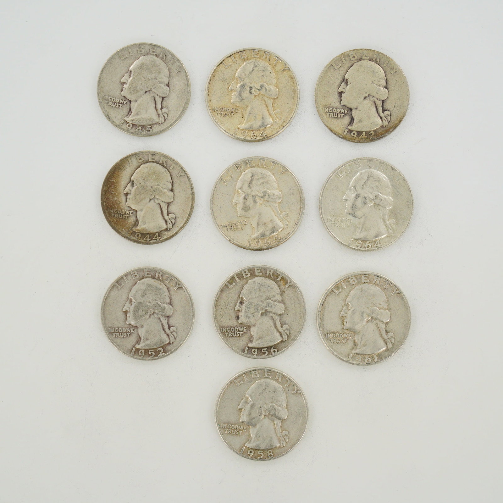 10pc Collection of US Silver Washington Quarters, 1942-1964: This assortment consists of a mixed date bag of US Washington Quarters produced in 1964 and earlier. Each coin is struck in a composition of 90% silver and 10% copper. The obverse features the left-fa