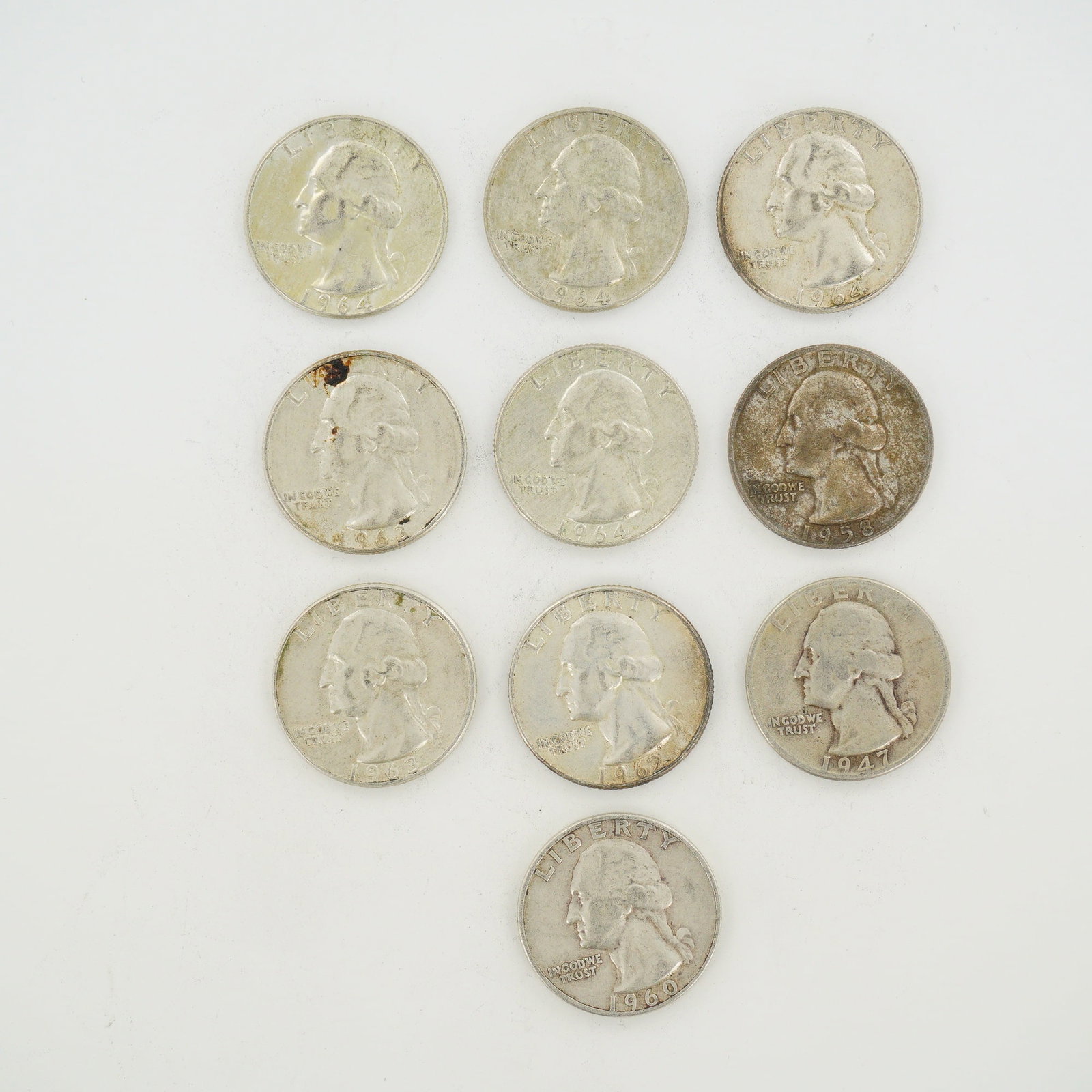 10pc Group of US Silver Washington Quarters, 1947-1964: A group of US Washington silver quarters produced prior to 1965. This mixed date bag of coins includes specimens dated 1947, 1958, 1960, 1962, 1963, and 1964. Each coin is composed of 90% silver and 1