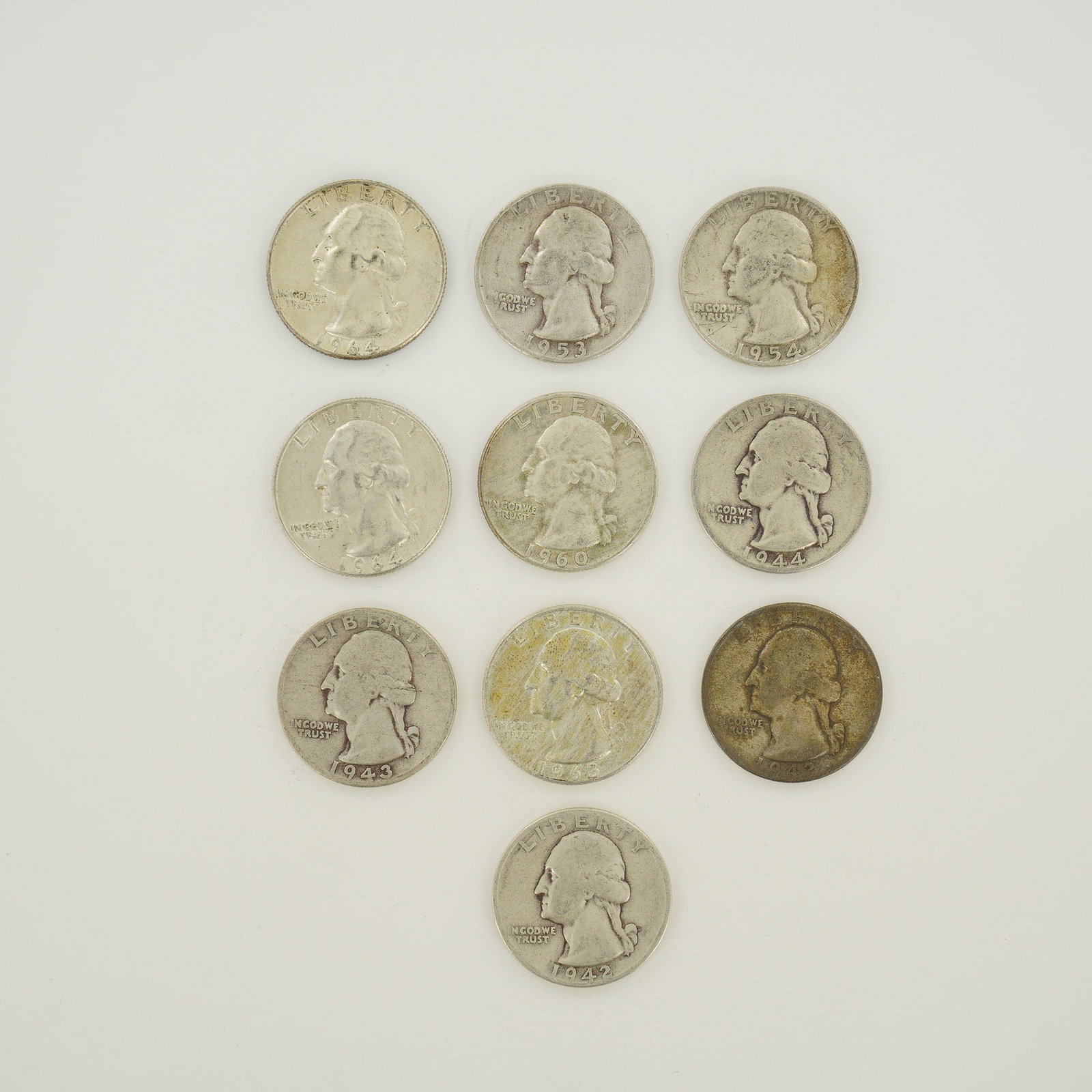 Ten US 90% Silver Washington Quarter Dollars, 1942-1964: Ten US Washington Quarter Dollars struck in 90% silver. This mixed date bag of coins includes 1942, 1943, 1944, 1953, 1954, 1960, and 1964. The coins feature the Washington obverse and the heraldic ea