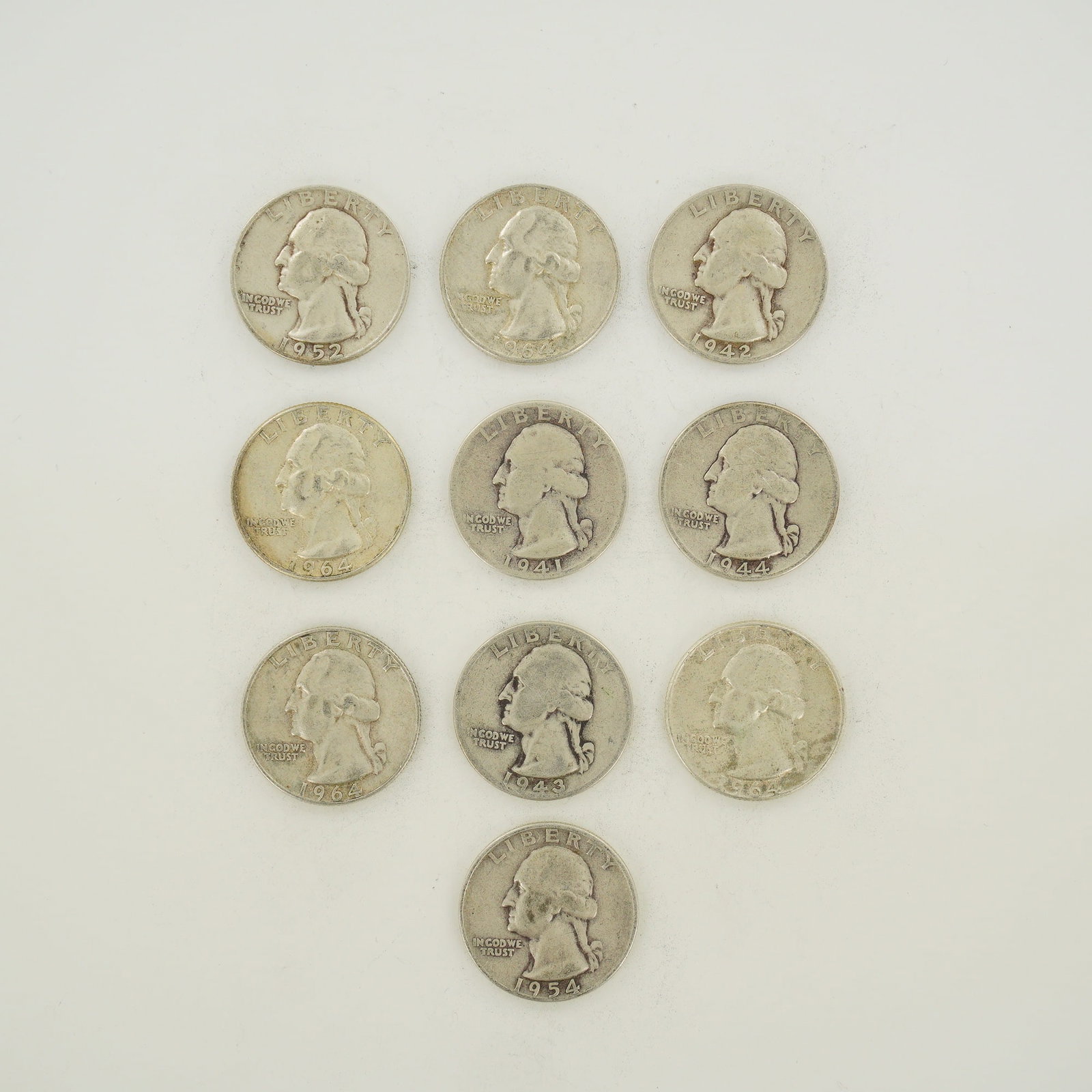10pc Collection of US 90% Silver Washington Quarters, 1941-1964: A collection of US Washington quarters struck in 90% silver. This mixed date bag of coinage includes various dates such as 1941, 1942, 1943, 1944, 1952, 1954, and 1964. The coins feature the Washingto