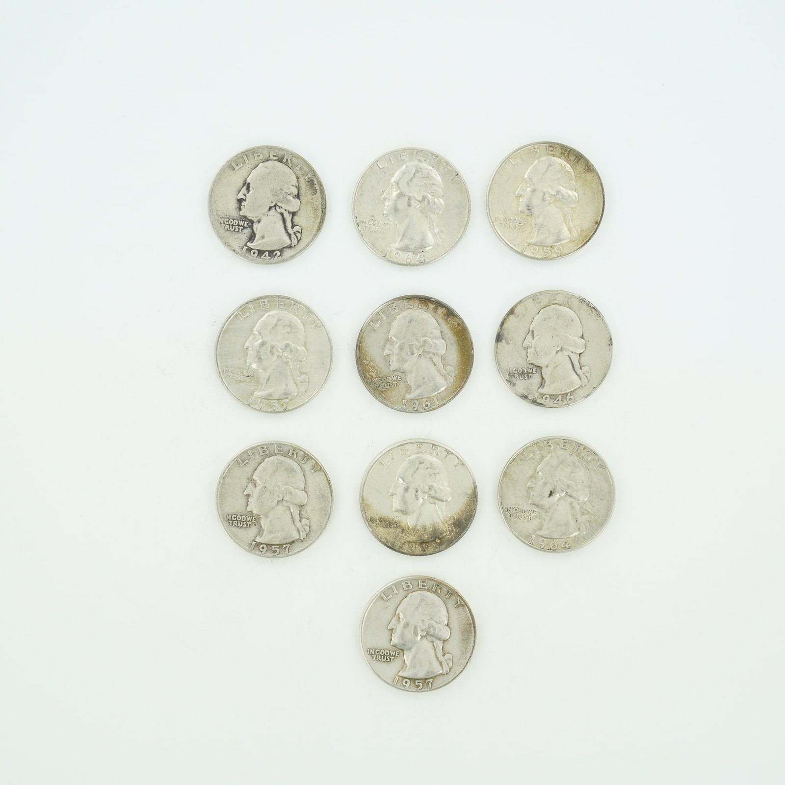 10pc Pre-1964 U.S. 90% Silver Washington Quarters: This lot features a mixed date bag of US Washington quarters issued between 1941 and 1964. Each specimen is composed of 90% silver with a reeded edge. The collection includes coins with the Washington
