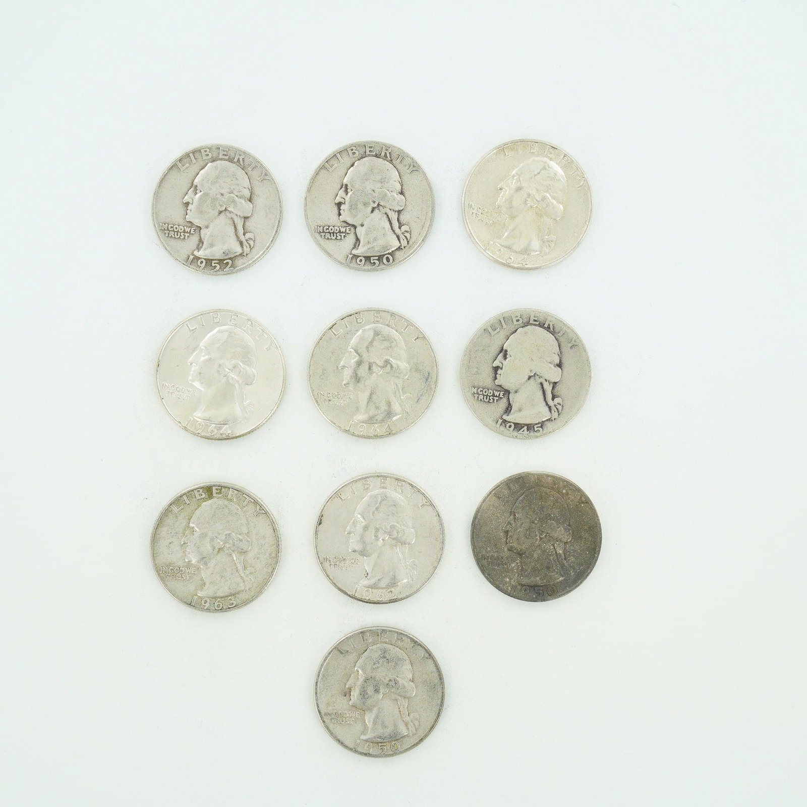 10pc Pre-1964 U.S. 90% Silver Washington Quarters: A collection of US Washington quarter dollars struck in 90% silver. This mixed date bag of coins includes examples dated 1945, 1950, 1952, 1962, 1963, and 1964. The obverse of each coin features the W