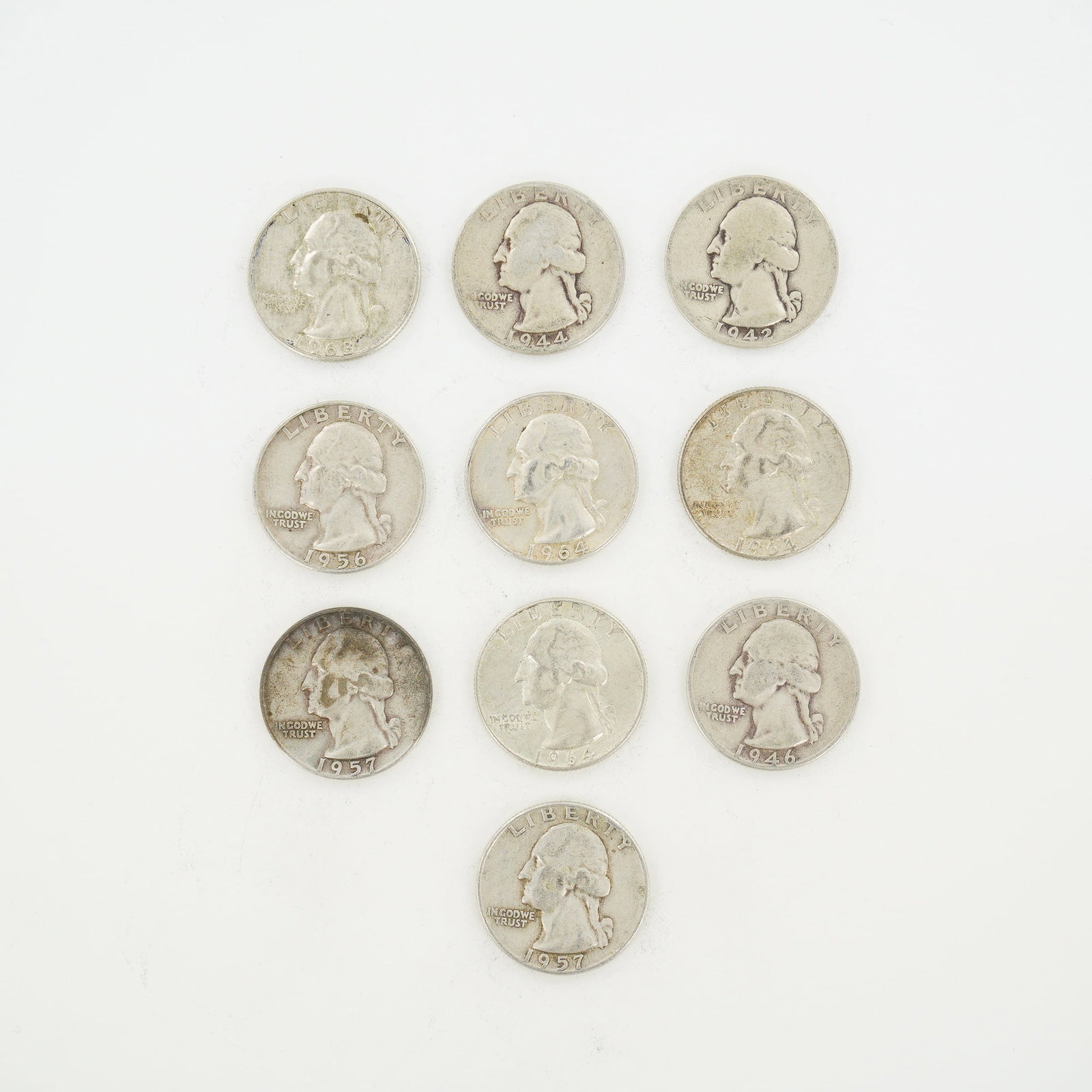 10pc Pre-1964 U.S. 90% Silver Washington Quarters: A collection of ten US Washington type quarters struck in 90% silver. The assortment includes mintage dates 1942, 1944, 1946, 1956, 1957, 1963, and 1964. Mint marks present include the D mark for the
