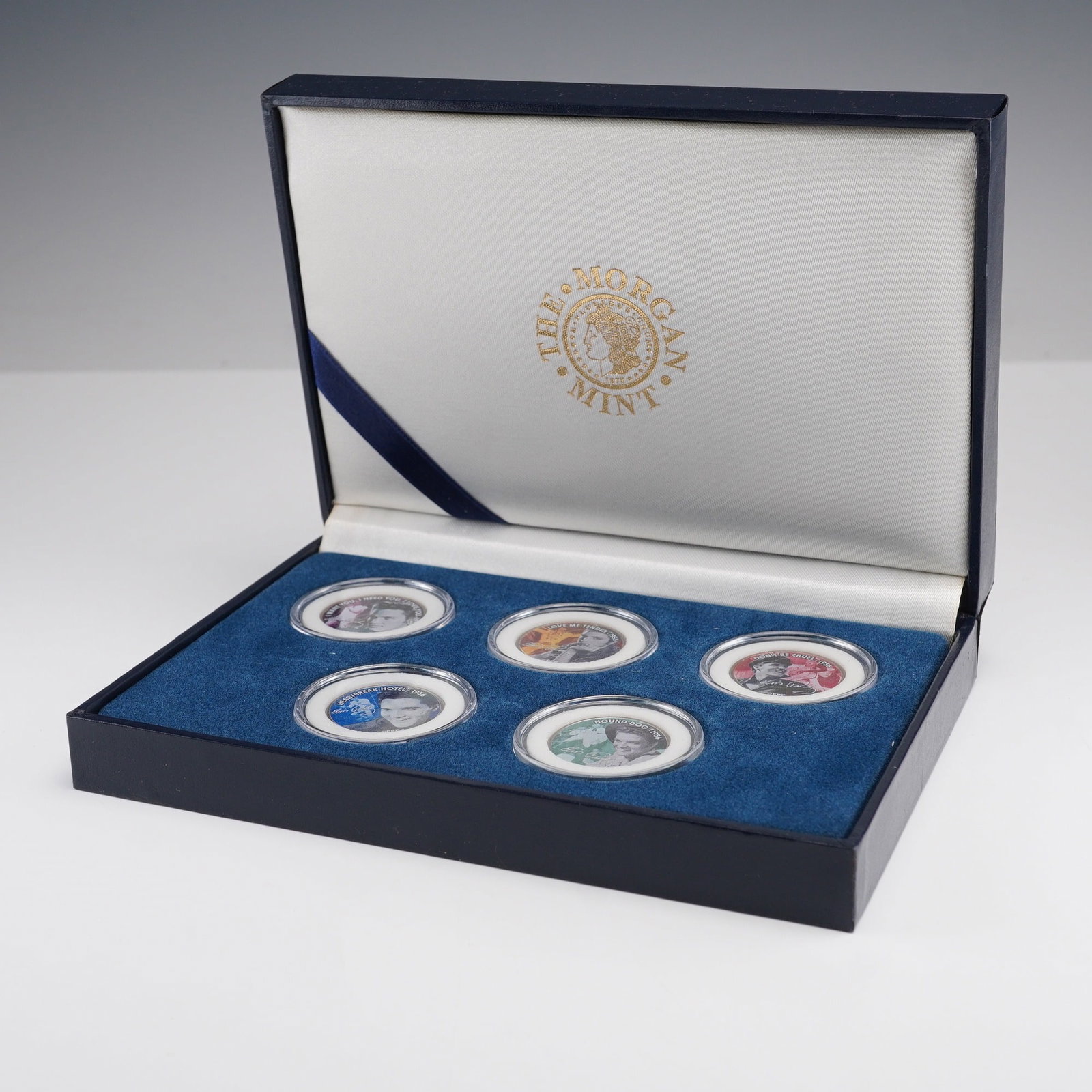 Elvis Presley 50th Anniversary Statehood Quarter Dollar Collector Set: A five-coin special edition Elvis Presley 50th Anniversary collector set issued by The Morgan Mint, housed in a blue presentation case with a Certificate of Authenticity. Each coin is a genuine United