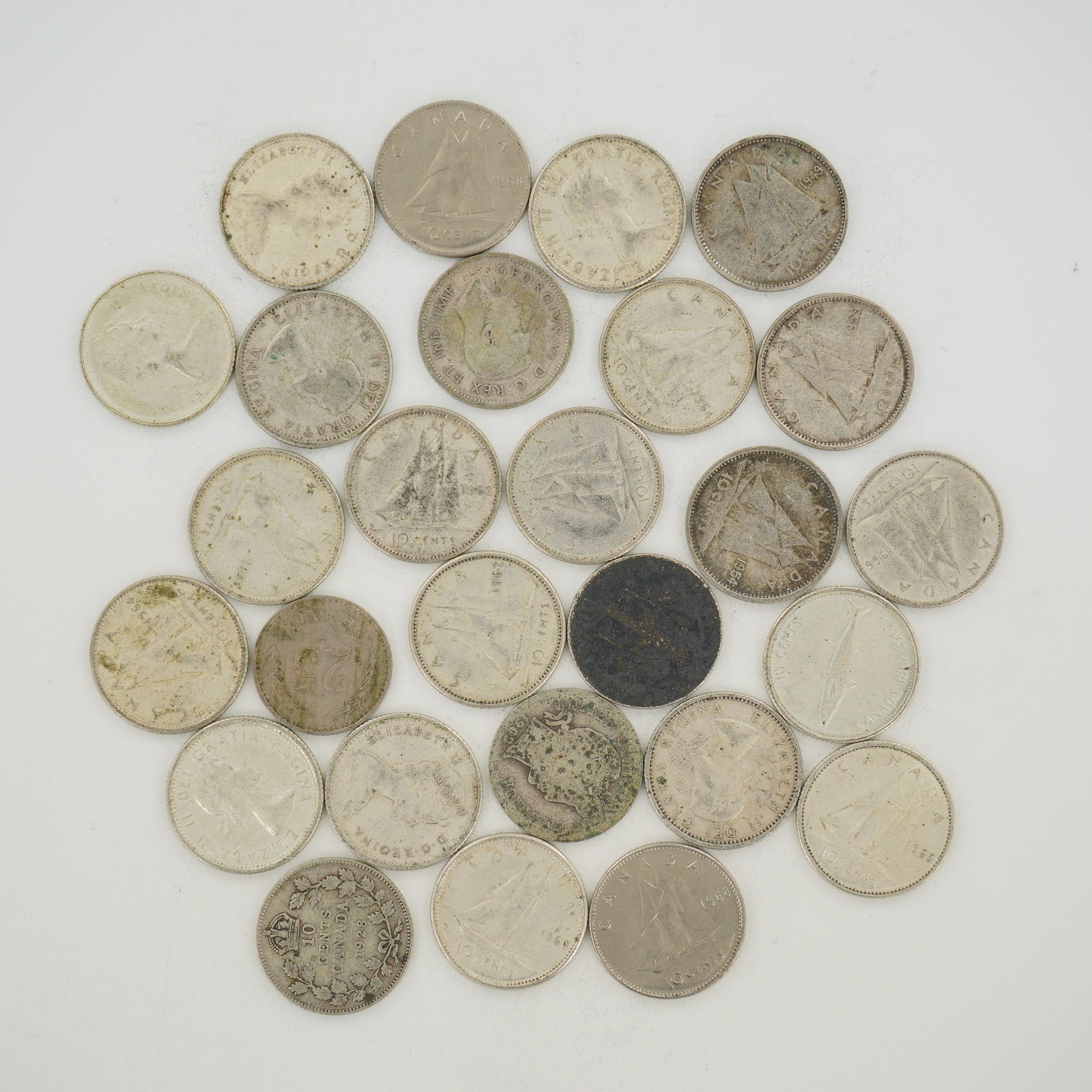 A Collection of CA Mixed Silver Dimes and a Quarter: A collection of CA coins featuring mixed silver dimes. The group features various obverse effigies of British and Canadian monarchs including King George V with the inscription GEORGIVS V DEI GRA: REX