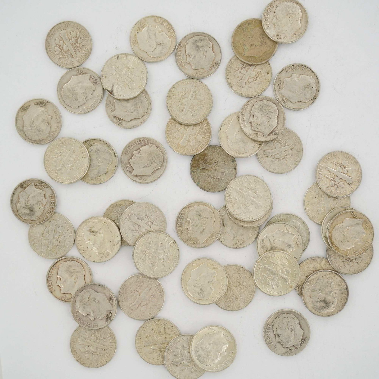 A Collection of US 90% Silver Roosevelt Dimes, Mixed Date Bag: A collection of US 90% silver coins, specifically Roosevelt dimes minted pre-1965. This mixed date bag of coinage includes specimens dated from 1946 through 1964. The assortment contains various mint 