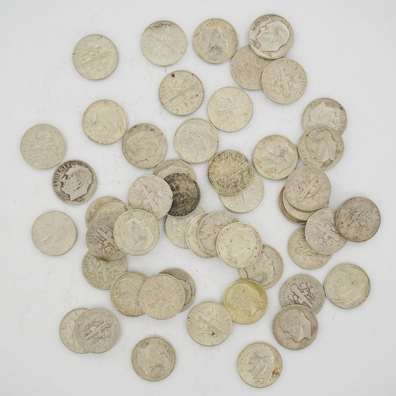 A Collection of US 90% Silver Roosevelt Dimes, Mixed Date Bag: This collection of US Roosevelt dimes is a mixed date bag of 90% silver coinage. The lot includes specimens with visible dates of 1951, 1952, and 1964. Each coin features the Roosevelt obverse and the