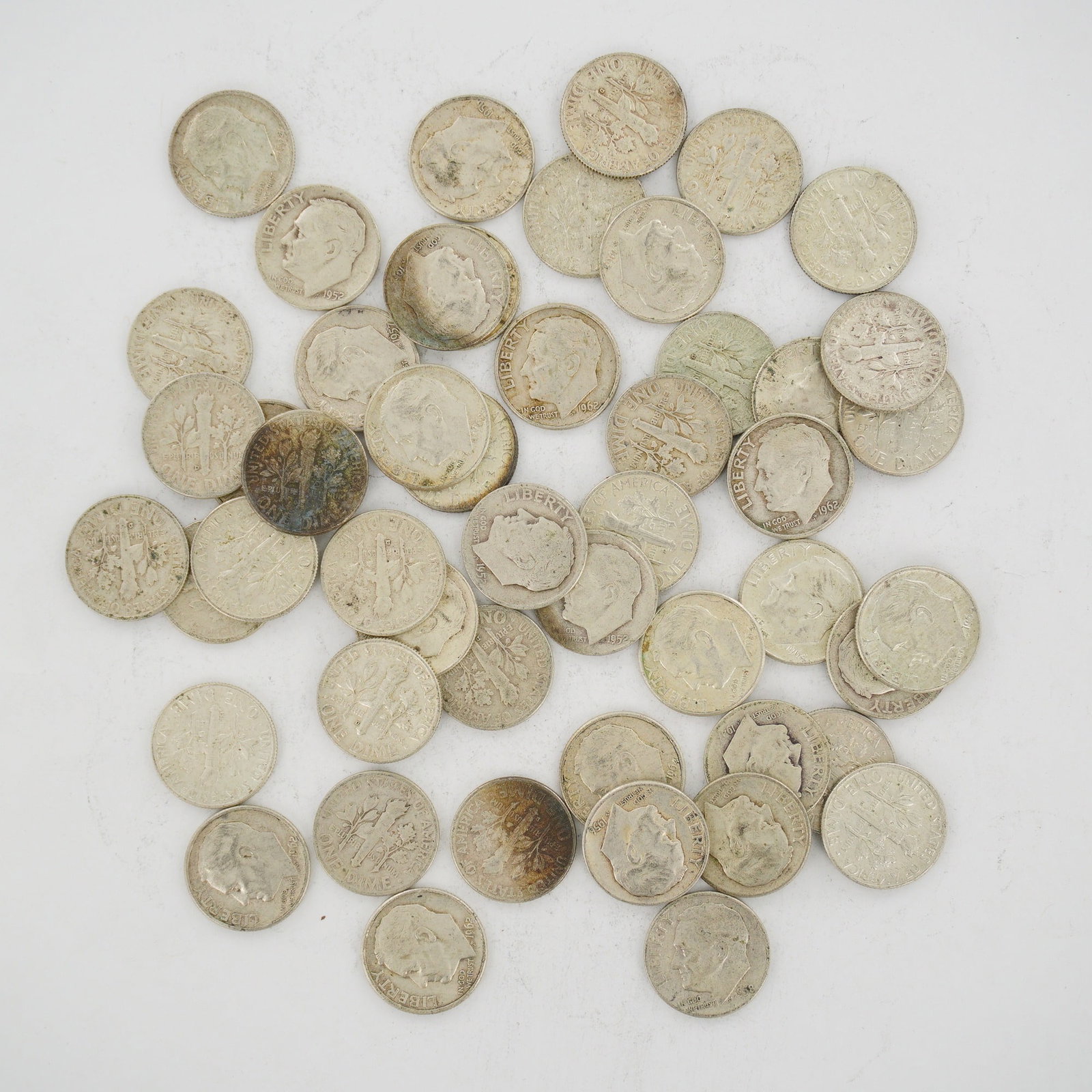 A Collection of US Roosevelt Dimes 90 Percent Silver Mixed Dates: This collection consists of a mixed date bag of US Roosevelt dimes struck in 90 percent silver. The group includes various dates such as 1952, 1956, 1957, 1962, and 1964. Each coin features the