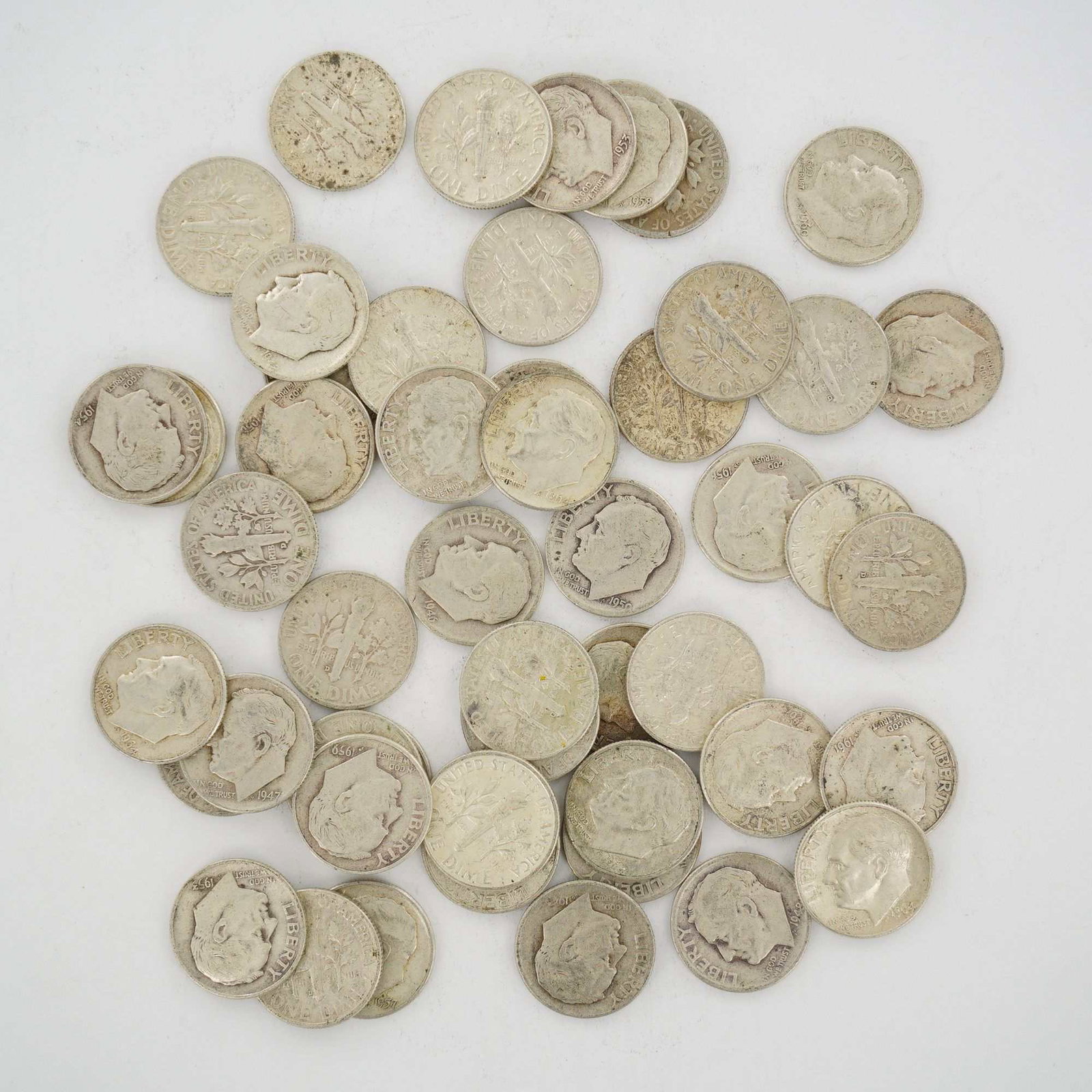 A Group of United States 90% Silver Roosevelt Dimes: This mixed date bag of United States silver coins consists of Roosevelt dimes minted in 90% silver. The collection includes various dates from the mid-20th century. Each coin features the obverse