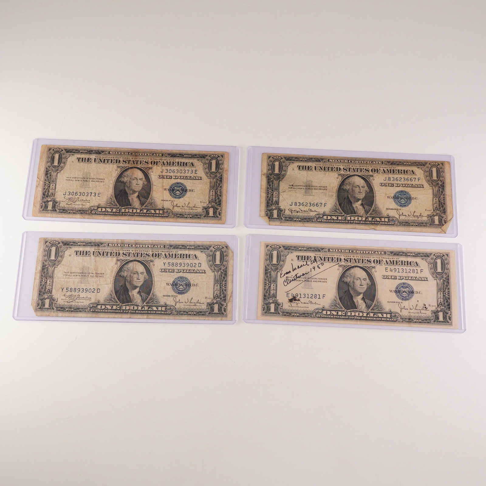 4pc 1935 C,D U.S. Silver Certificate One Dollar Notes: Silver Certificate notes from Series 1935C and 1935D, including two examples of each. Each note features the portrait of George Washington at center, blue Treasury seal and serial numbers, and the leg