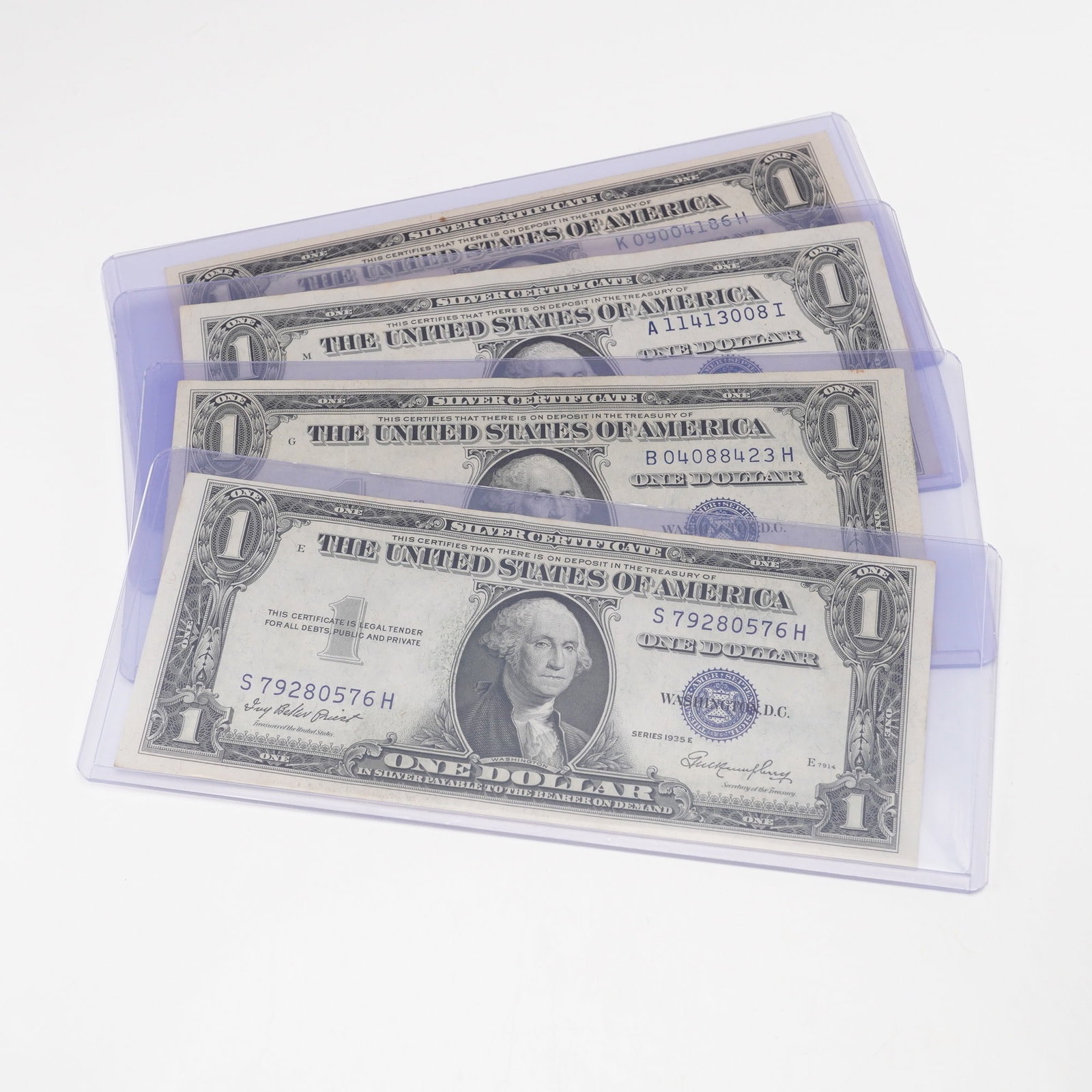 4pc 1935E U.S. Silver Certificate One Dollar Notes: Silver Certificate one dollar notes, each featuring the blue Treasury seal and serial numbers with the Washington portrait at center. The obverse inscriptions include Silver Certificate, This certifie