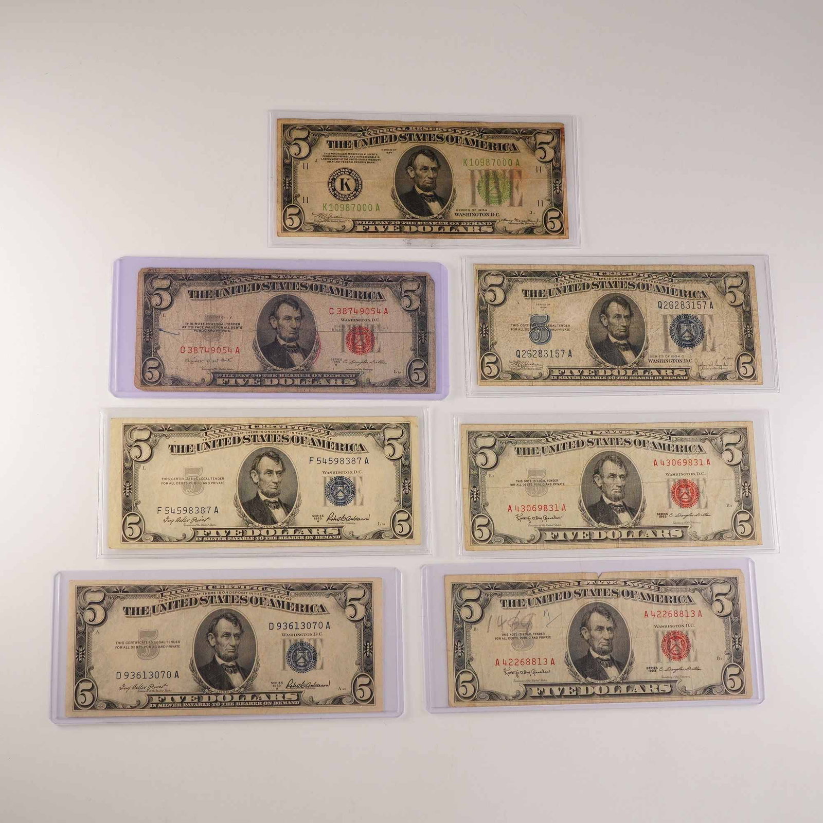 7pc 1934, 1953 & 1963 United States $5 Banknotes: A varied group of seven United States five-dollar bills representing multiple series and seal colors. This collection includes examples of both red seal United States Notes and blue or green seal Fede