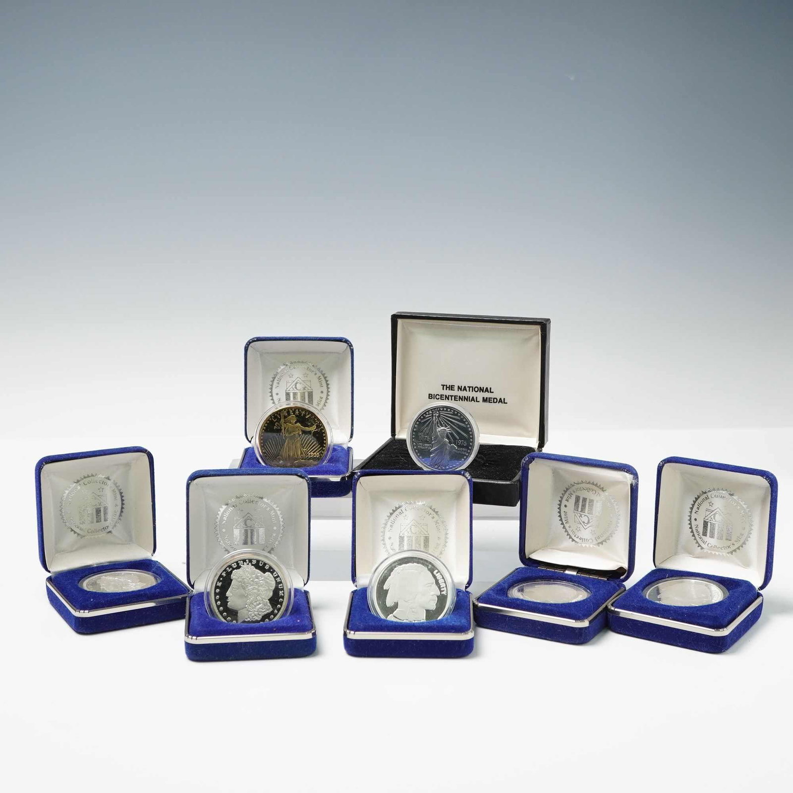 7pc National Collectors Mint Silver Replica Rounds and Medal: Includes two 1889 Morgan Silver Dollar replicas designed with Liberty head facing left on the obverse and an eagle holding arrows and an olive branch, within wreath, along with the serial number on