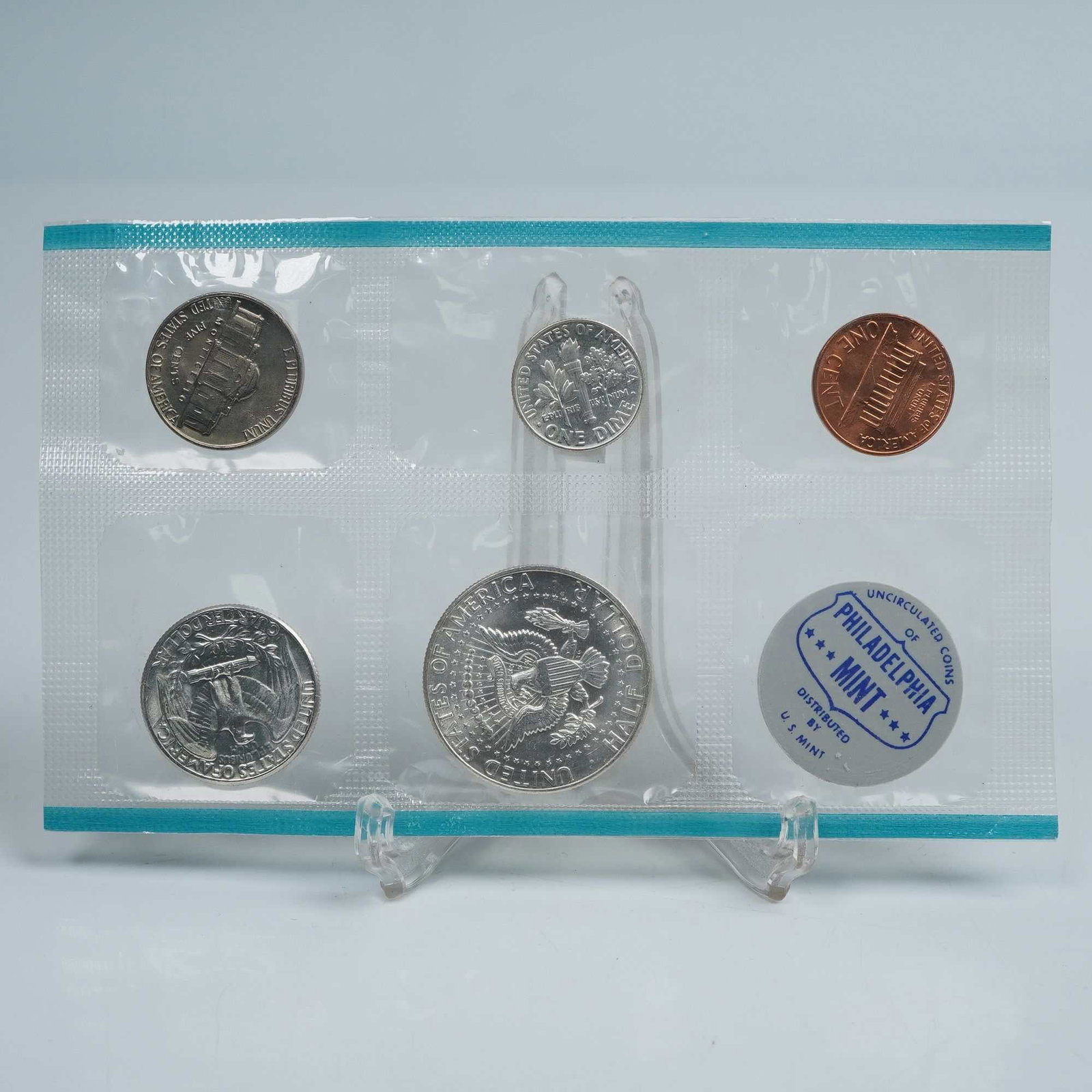1964 Set of 6 U.S. Philadelphia Mint Uncirculated Coins: A complete 1964 Philadelphia Mint uncirculated coin set housed in its original sealed mint packaging. The set includes five coins: Lincoln Cent, Jefferson Nickel, Roosevelt Dime, Washington Quarter,