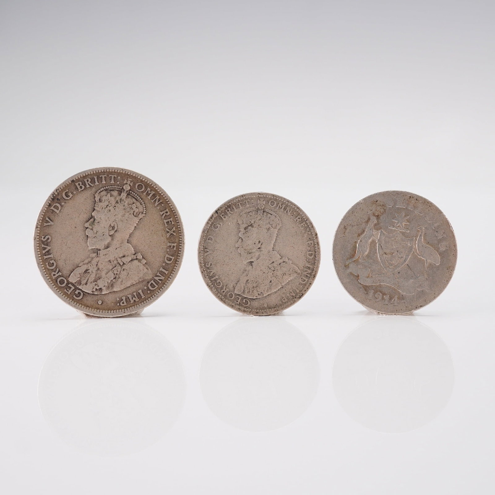 3pc Australian 1911 1 Florin & 1914 to 1915 1 Shilling George V Coins: Each coin is struck in 92.5 percent silver, with the florin containing approximately 11.31 grams of metal and each shilling approximately 5.65 grams. The obverses feature a left-facing portrait of Kin