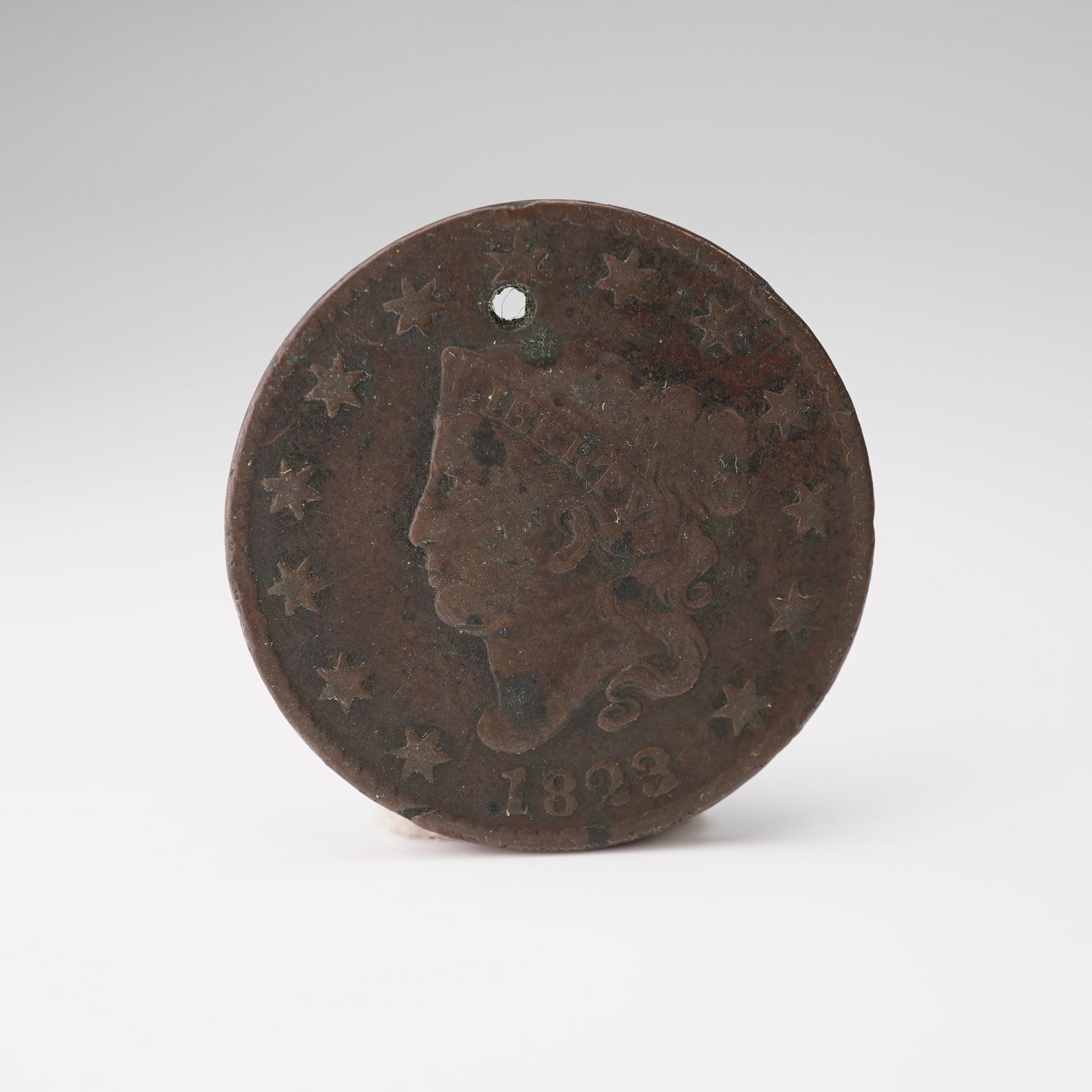 1823-(P) Liberty Head Type 1 Young Head 1 Cent Coin: Features the profile of Liberty facing left on the obverse, surrounded by thirteen stars representing the original colonies, with the inscription LIBERTY and the date 1823 below. The reverse displays 