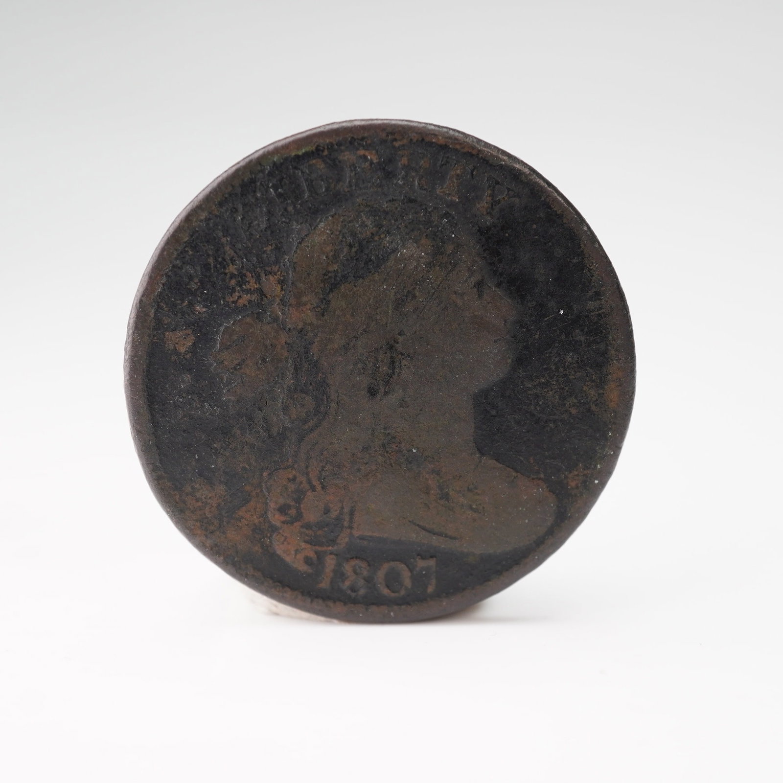 1807 Draped Bust 1 Cent Coin: Struck at the Philadelphia Mint, this early large cent features the classic Draped Bust. The obverse depicts Liberty facing right with flowing hair and the inscription LIBERTY above and the date 1807