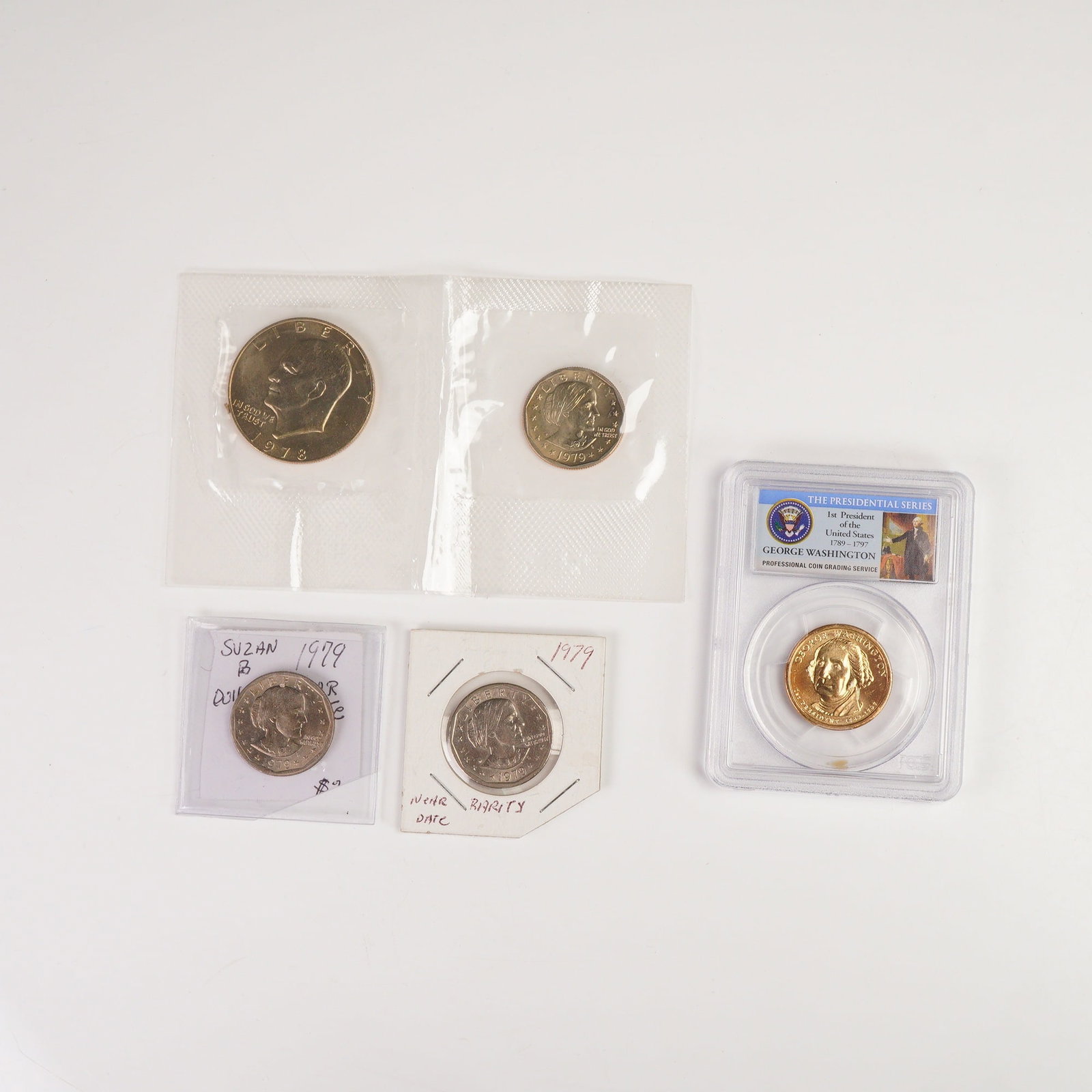 5pc 1978 to 2007 United States Graded & Ungraded Coins: Featuring an Eisenhower dollar dated 1978 displaying a left-facing portrait with the inscriptions LIBERTY and IN GOD WE TRUST on the obverse and a heraldic eagle with UNITED STATES OF AMERICA and ONE 
