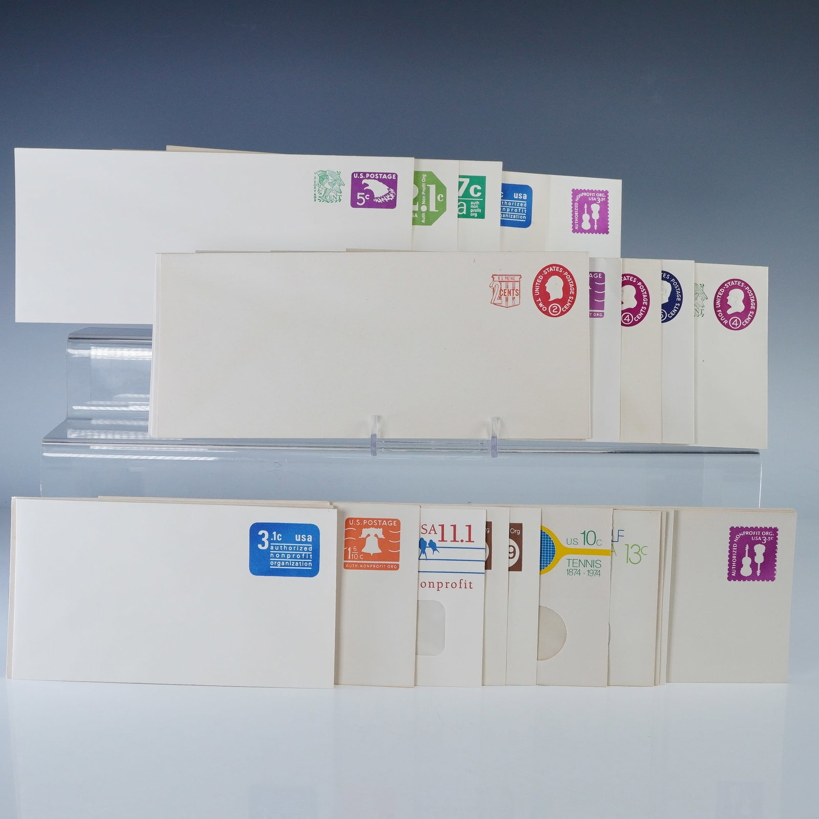 30pc Vintage US Postal Stationery Envelopes: Collection of thirty vintage United States postal stationery envelopes with pre-printed postage in assorted denominations and designs. Includes colorful examples featuring motifs such as the Liberty B