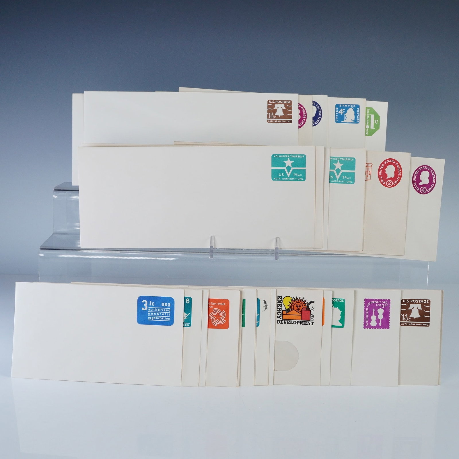 31pc Vintage US Postal Stationery Envelopes: Collection of thirty vintage United States postal stationery envelopes with pre-printed postage in assorted denominations and designs. Includes colorful examples featuring motifs such as the Liberty B