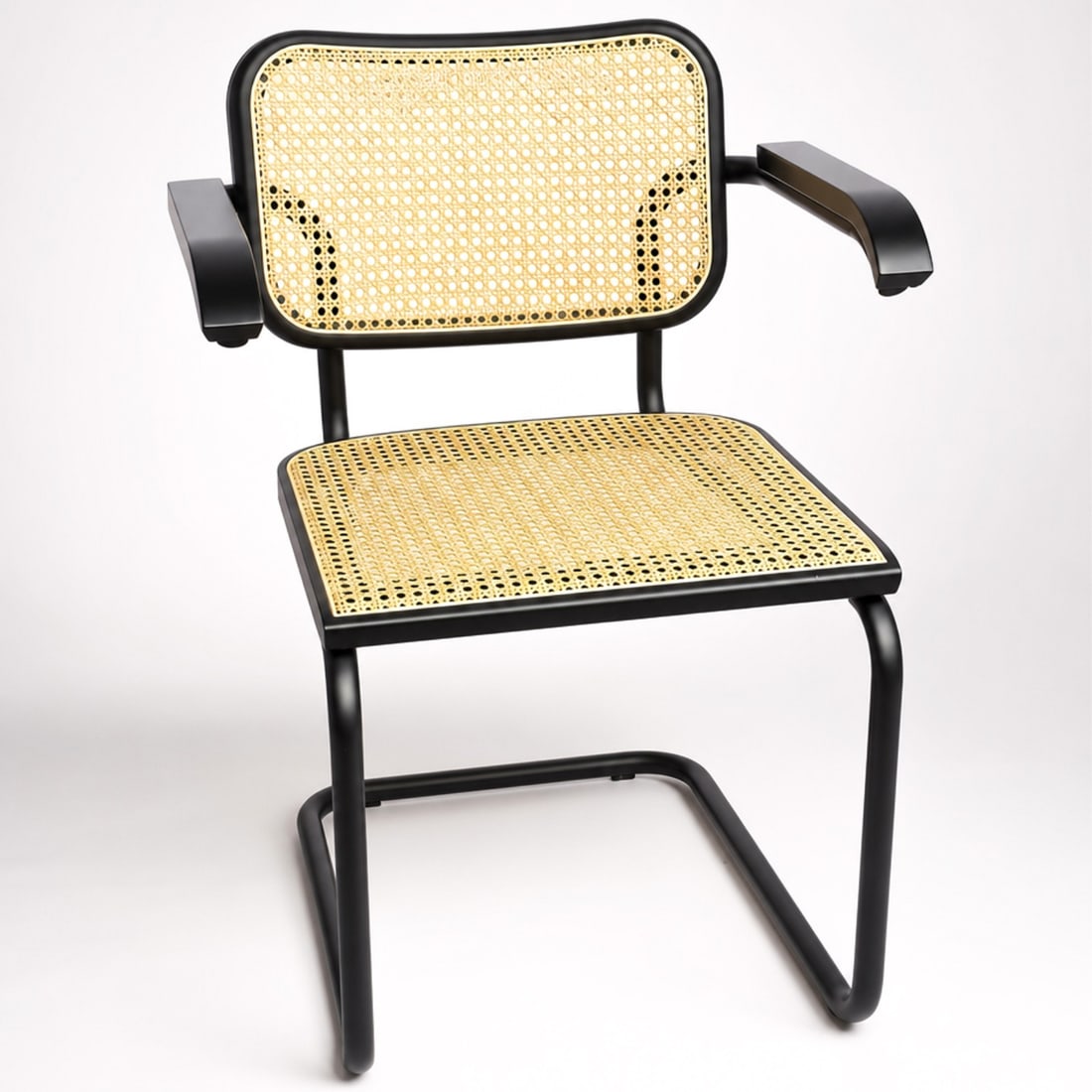 Knoll Cesca Collection Dining Armchair with Ebonized Beech Wood Finish: This dining armchair is part of the Knoll Cesca Collection, featuring the iconic cantilever design by Marcel Breuer. The chair is constructed with a continuous tubular steel frame in a black satin-lik