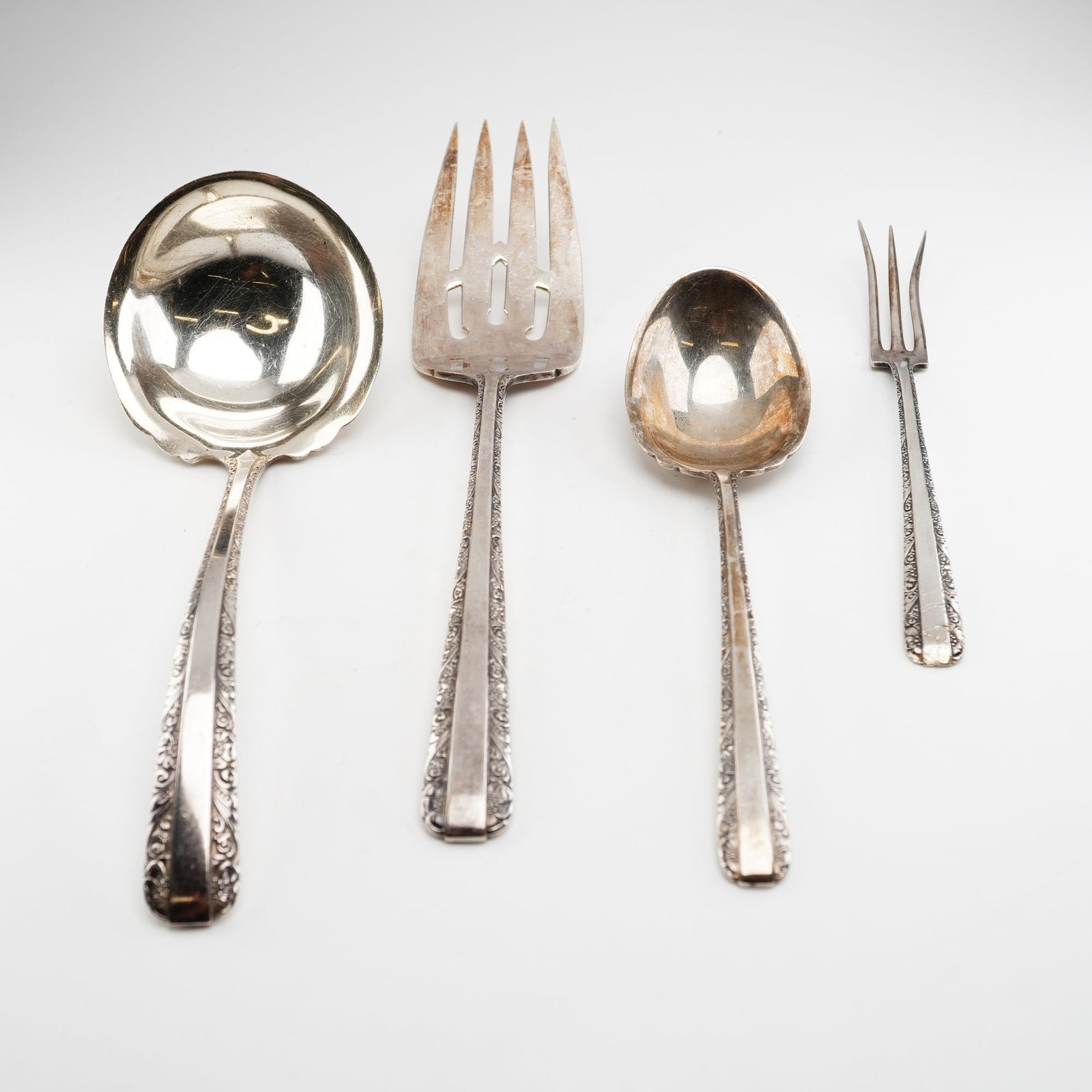 4pc Towle Candlelight Sterling Silver Flatware Set: This set of sterling silver flatware was manufactured by Towle Silversmiths in the Candlelight pattern, first introduced in 1934. The pattern is characterized by ornate floral and scroll-work borders 