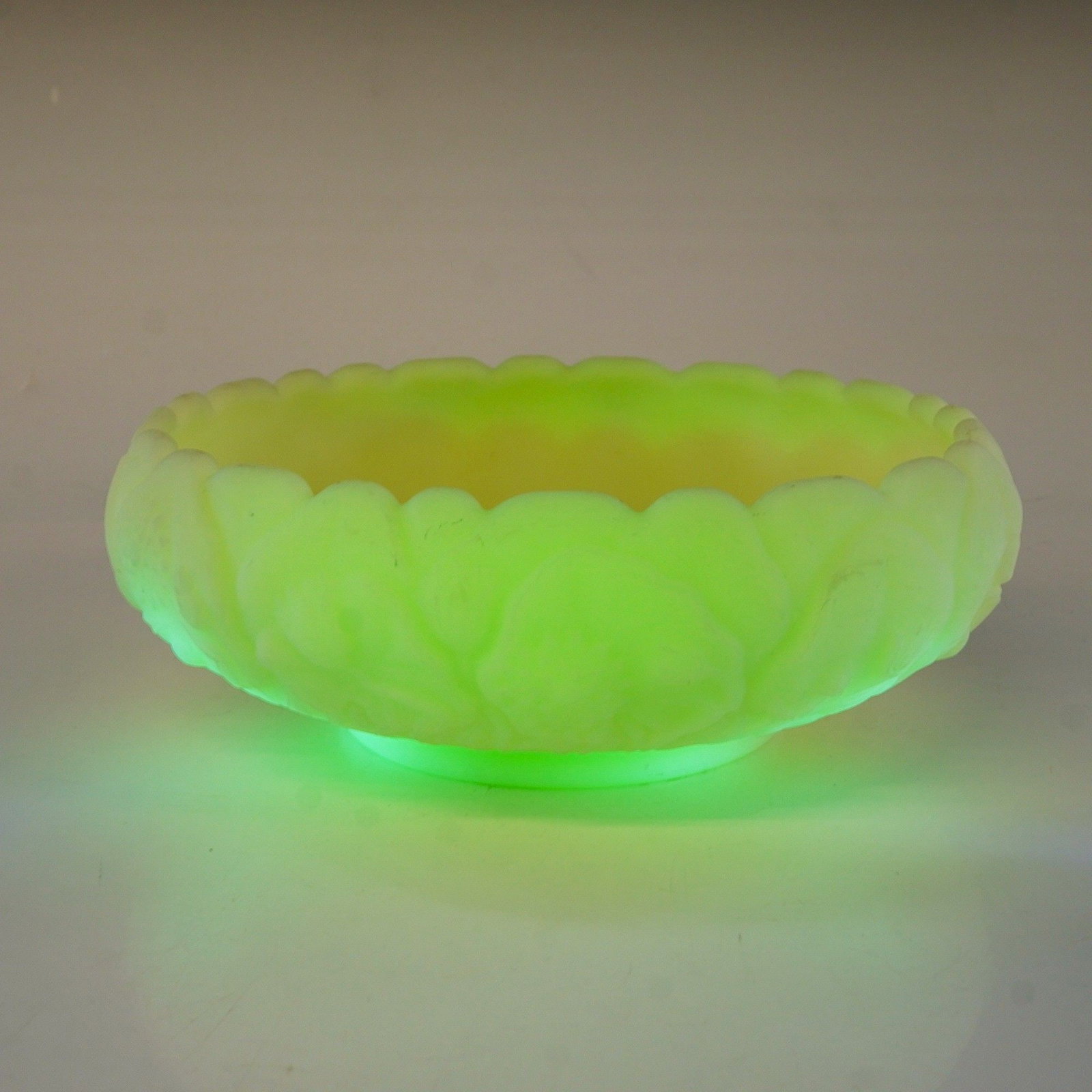 Fenton Water Lily Custard Satin Uranium Glass Bowl: This vintage bowl was manufactured by the Fenton Art Glass Company and features the embossed Water Lily pattern. The piece is made of custard glass, an opaque uranium glass that displays a vivid green