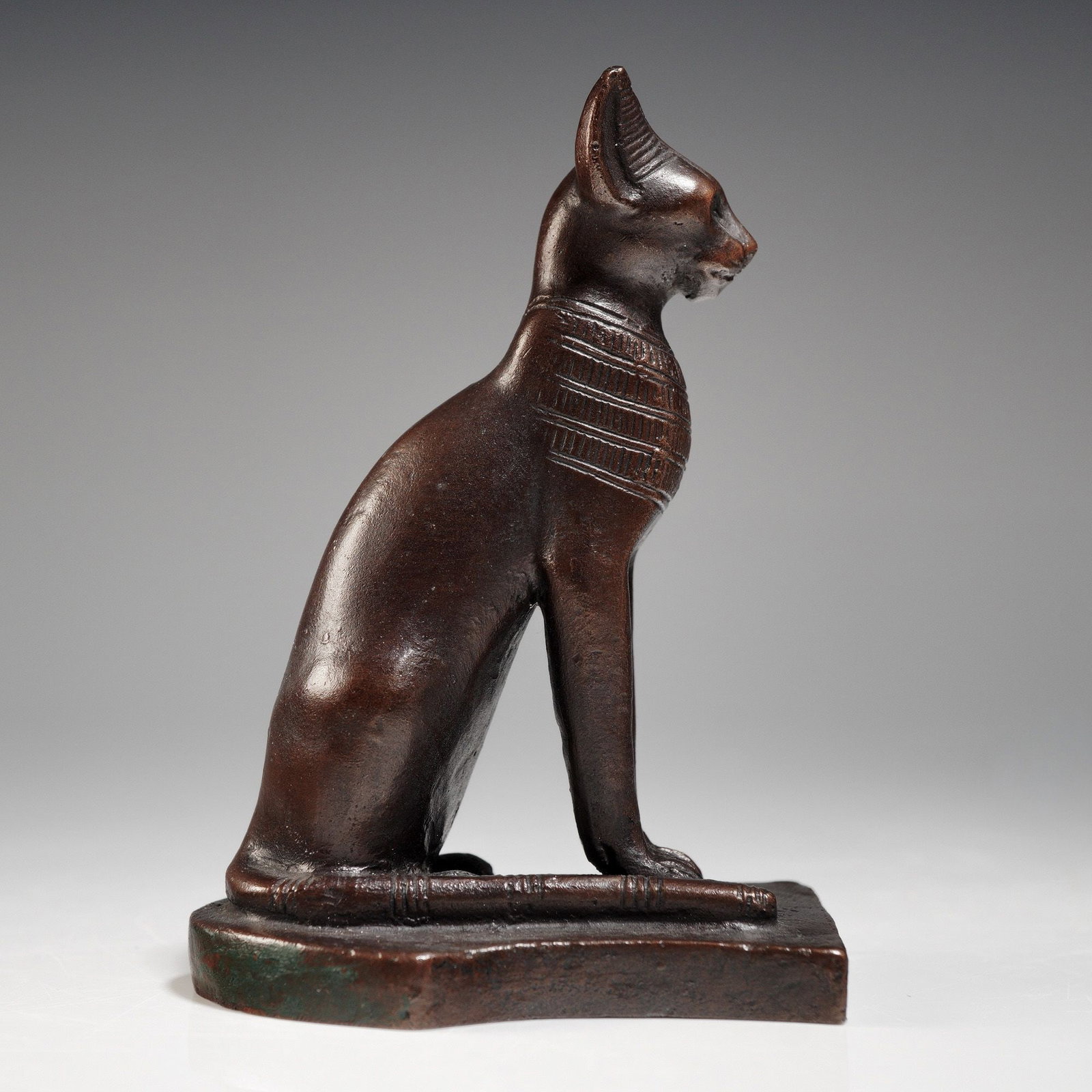 Metropolitan Museum of Art Reproduction of Egyptian Bastet Cat Statuette: A statuette authorized and produced by the Metropolitan Museum of Art (MMA), replicating an Ancient Egyptian seated cat figure, likely representing the deity Bastet. The figure is cast in a material w