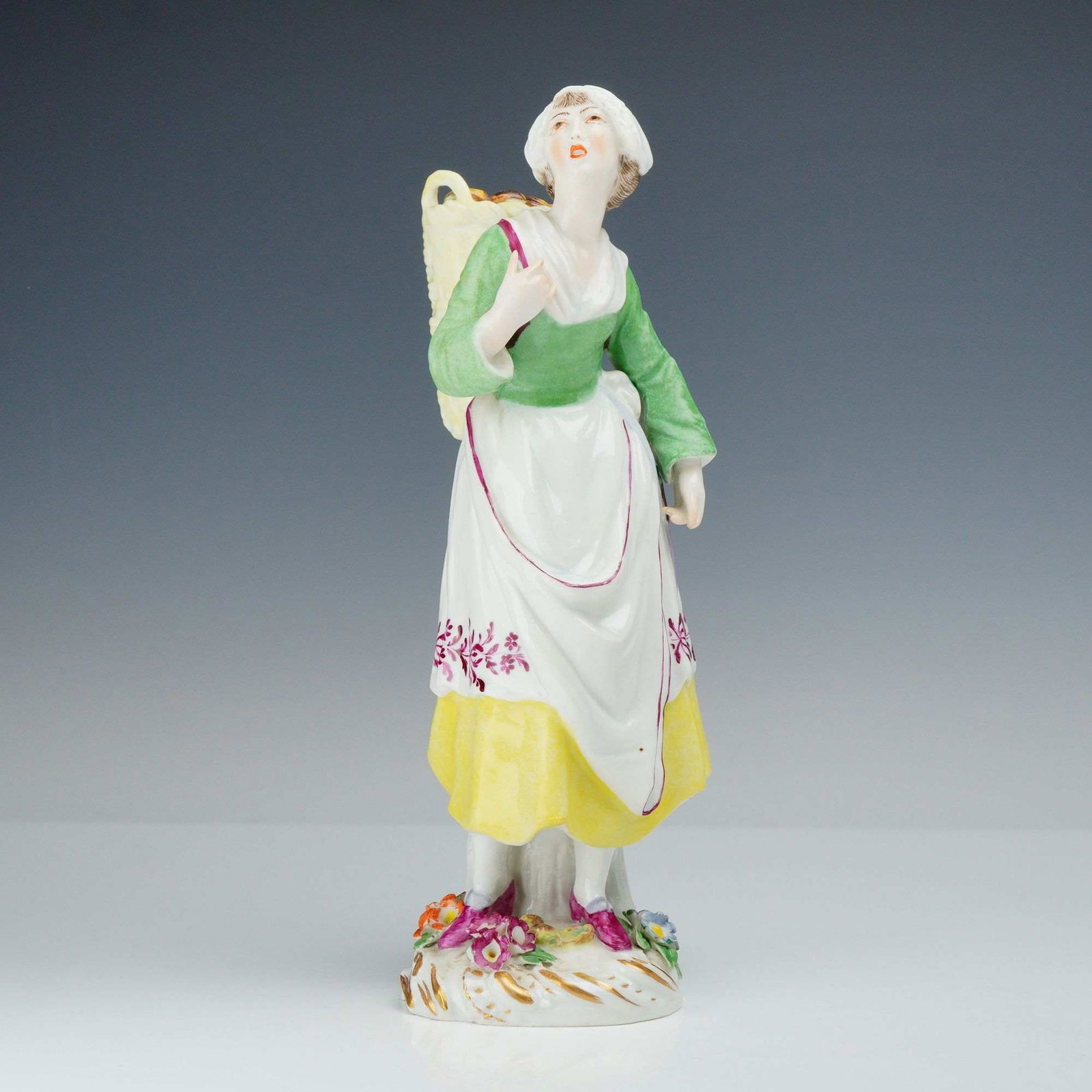 Meissen Oyster Seller Porcelain Figurine, Cries of Paris: A Meissen polychrome glazed and gilded porcelain figurine from the Cries of Paris series, depicting an oyster seller. The figure is modeled standing and looking upward, carrying a large yellow wicker 