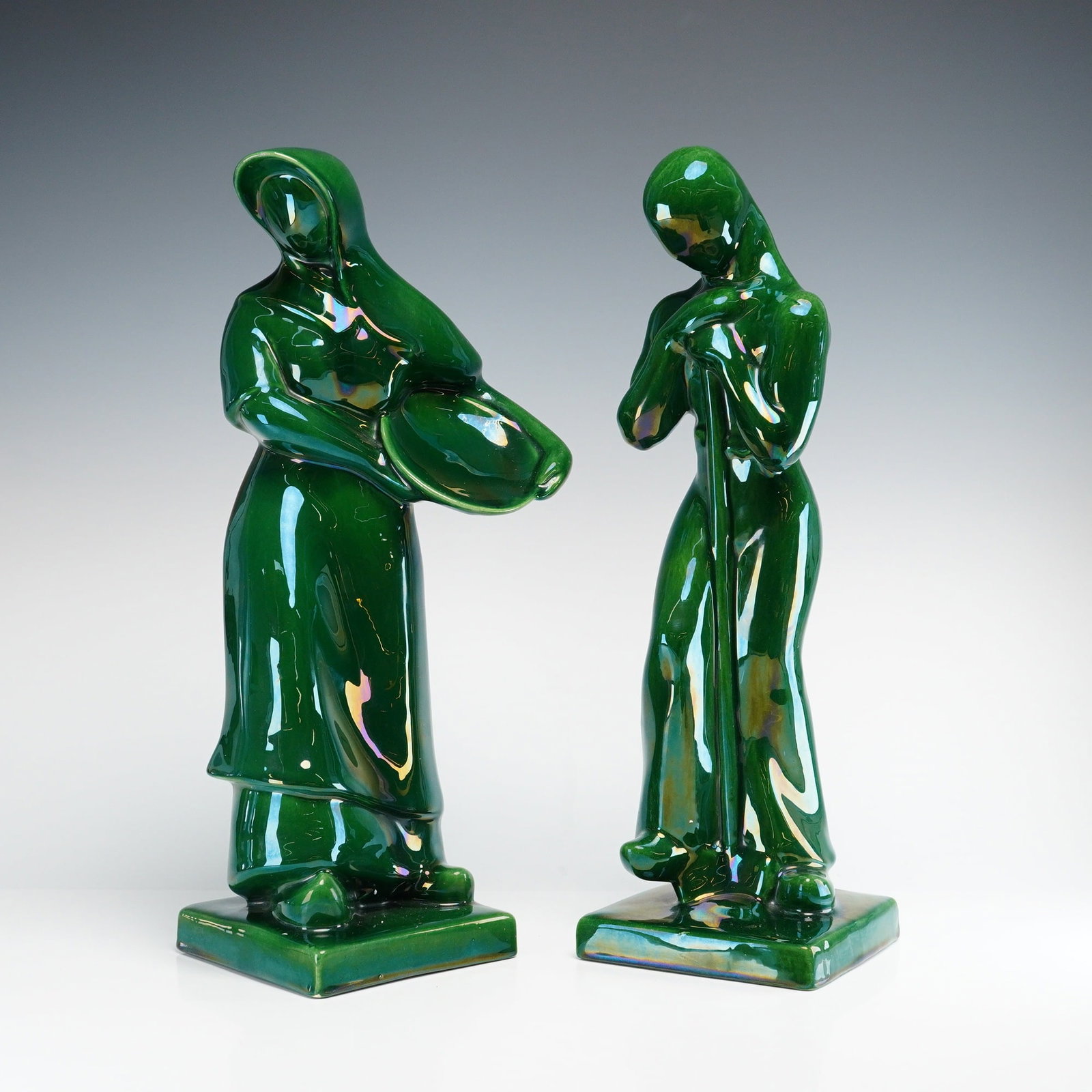2pc Royal Haeger Ceramic Peasant Figures, R382 and R383: A pair of Royal Haeger ceramic peasant figures featuring a stylized mid-century modern design with simplified, flowing forms. The male figure, model R382, is depicted leaning forward on a long staff.