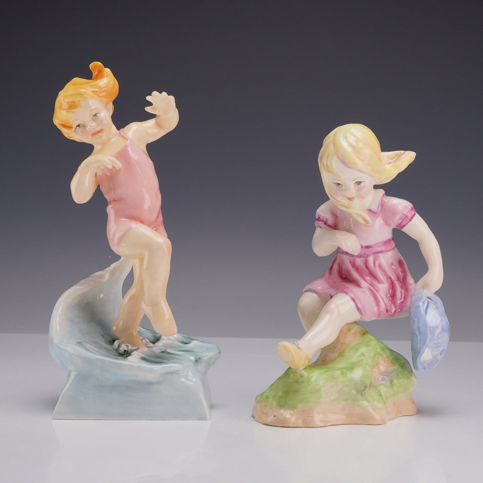 2pc Royal Worcester Porcelain Figurines March and July Modeled by Freda Doughty: A pair of Royal Worcester glazed polychrome fine bone china figurines from the Months of the Year series, modeled by Freda Doughty. The figure titled July (Model 3440) depicts a girl with reddish-blon