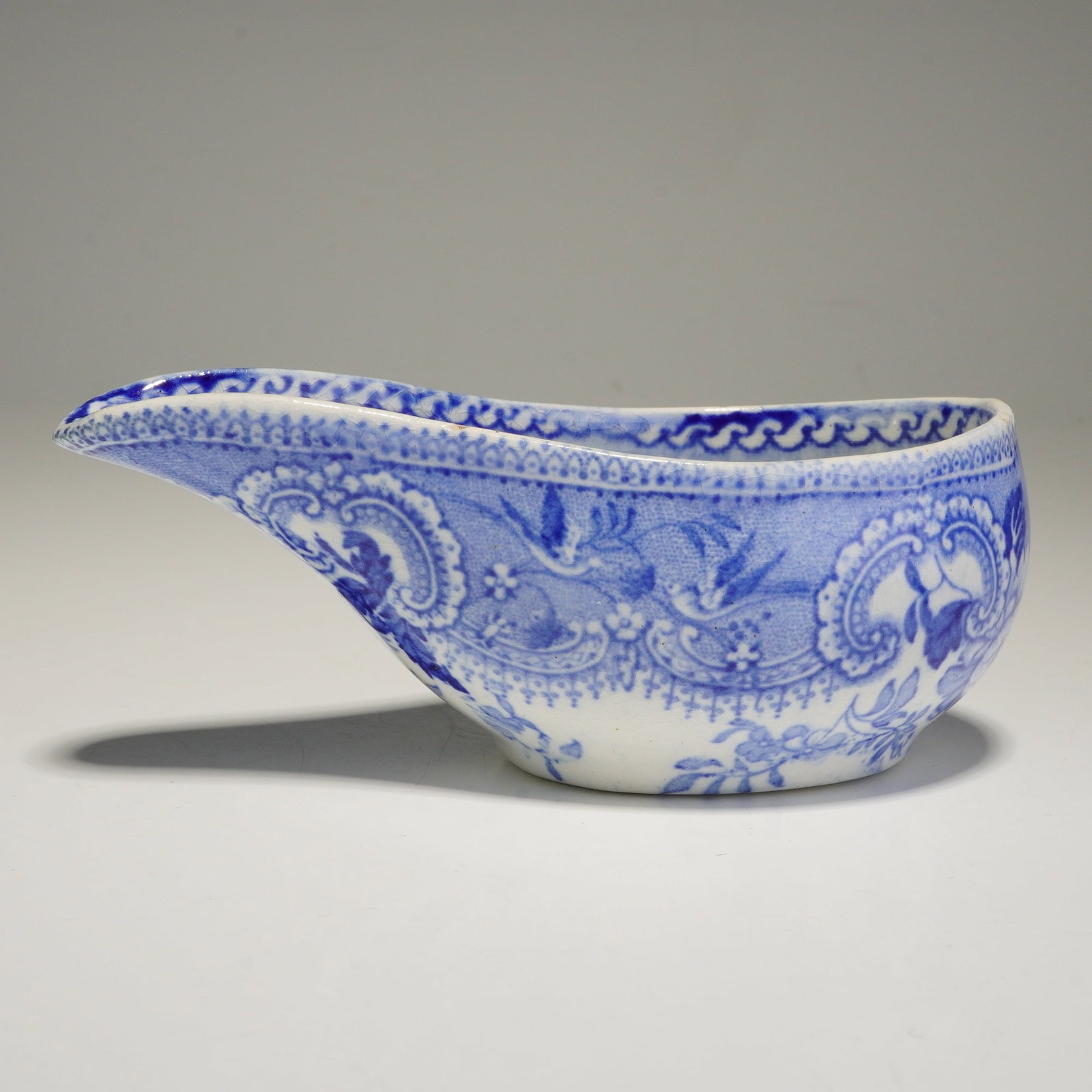 A 19th Century Davenport Blue and White Transfer-Printed Small Pouring Vessel (Pap Boat): This 19th-century Davenport ceramic small pouring vessel (pap boat), also utilized as an invalid feeder, features a classic blue and white transfer-printed design. The vessel is decorated with a patte