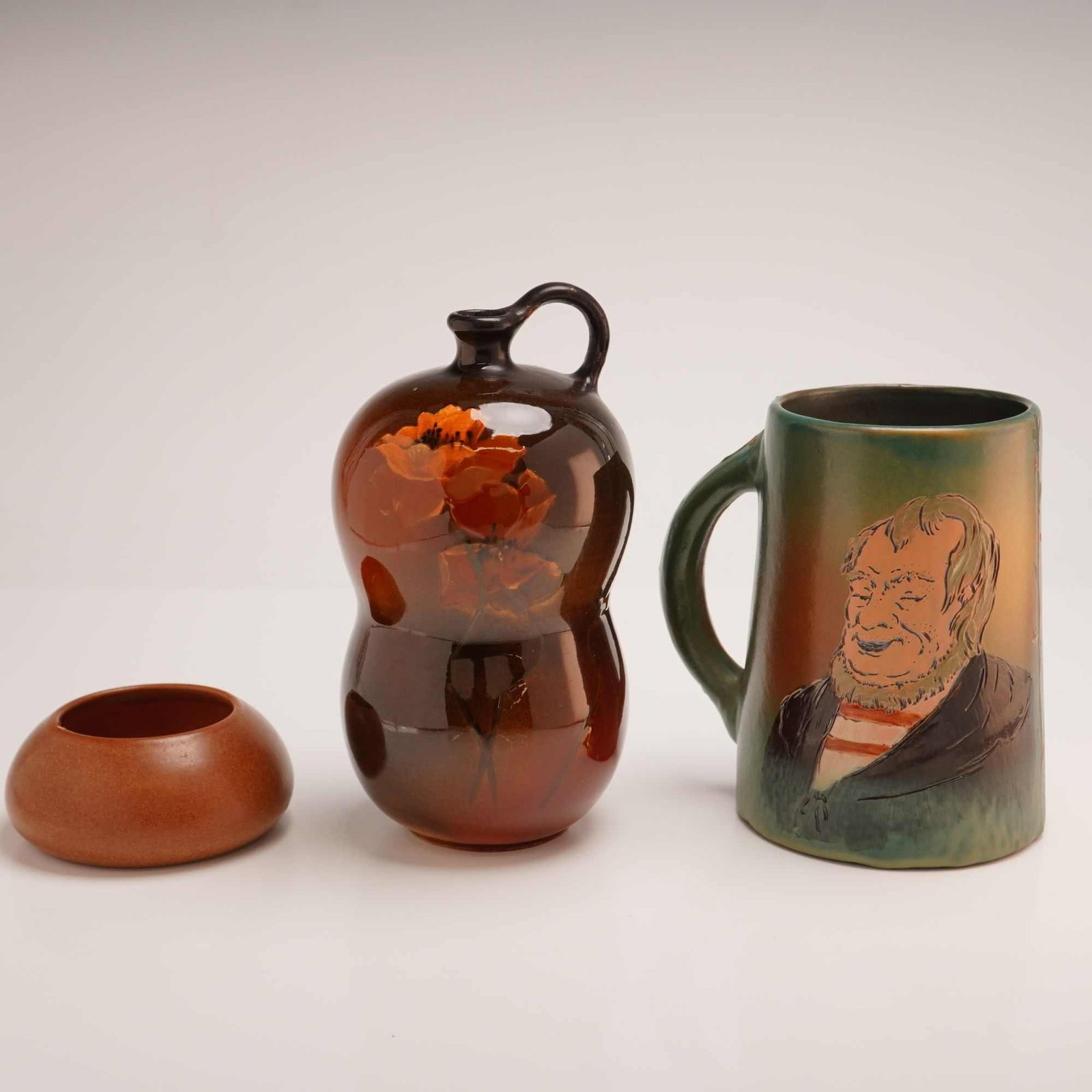3pc American Art Pottery Vessels Including Weller: This lot comprises three American art pottery vessels. The first is a Weller Pottery Louwelsa line gourd-shaped jug. It features a bi-lobed, earthenware body with an integrated loop handle and is