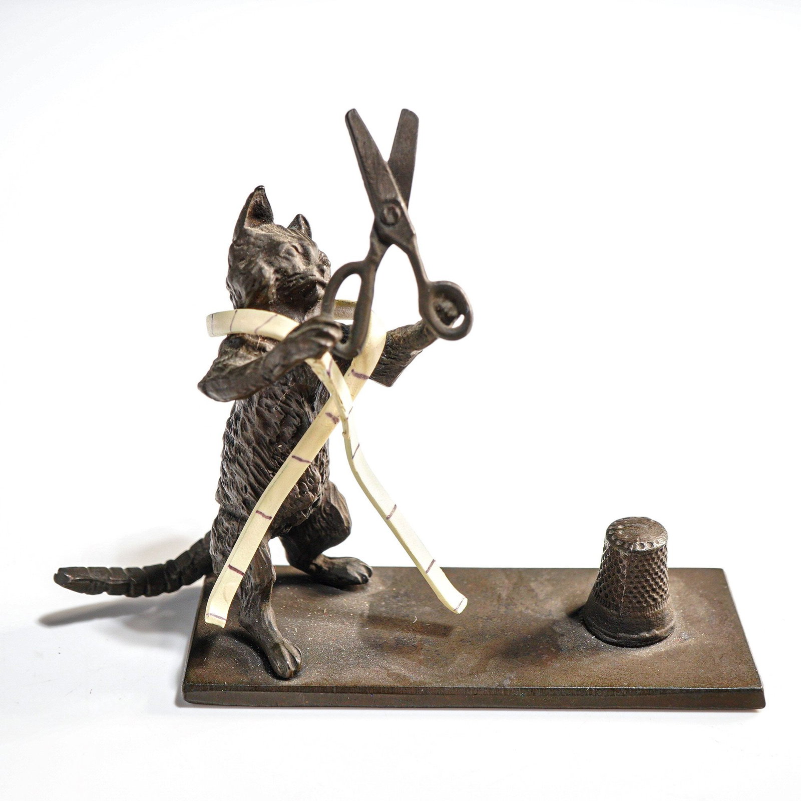 Heirloom Editions Redl Wien Cast Metal Cat Tailor Thimble Holder: A single cast metal figurine, identified as the Cat Tailor model produced by Heirloom Editions, associated with Redl Wien, USA. This desk accessory is styled in the manner of a Vienna Bronze and