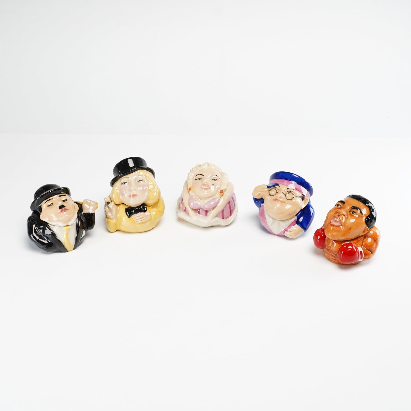 5pc Kevin Francis Face Pots, Cultural Icon Collection: A collection of five hand-painted glazed ceramic miniature lidded boxes from the Kevin Francis Face Pots series. Each piece features a caricature of a cultural icon as the lid, with the subject name