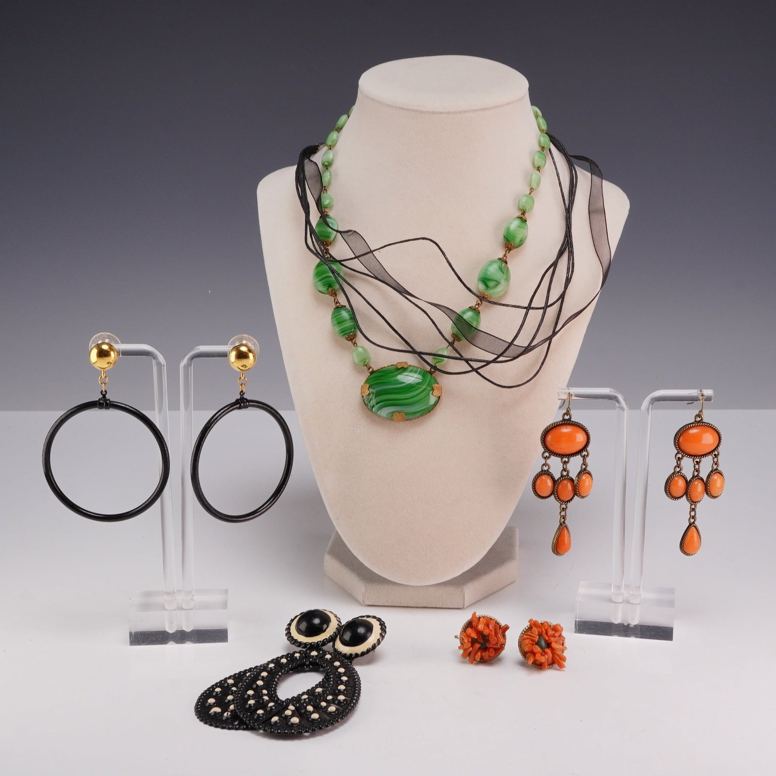Collection of Six Costume Jewelry Including Earrings and Necklaces: This 10pc costume jewelry collection consists of four pairs of earrings and two choker necklaces. One of the necklaces is a statement piece featuring a large oval green and white swirled slag glass