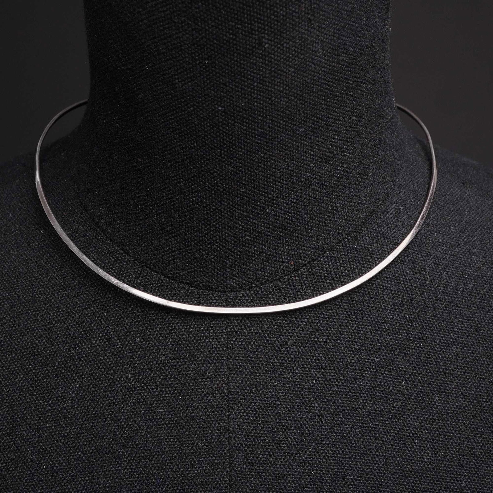 Silver-Toned Minimalist Rigid Wire Collar Costume Jewelry Necklace: A minimalist costume jewelry necklace featuring a rigid, open-ended collar design. The piece is constructed from a silver-toned metal wire with a square cross-section and flat terminal ends. This C-sh