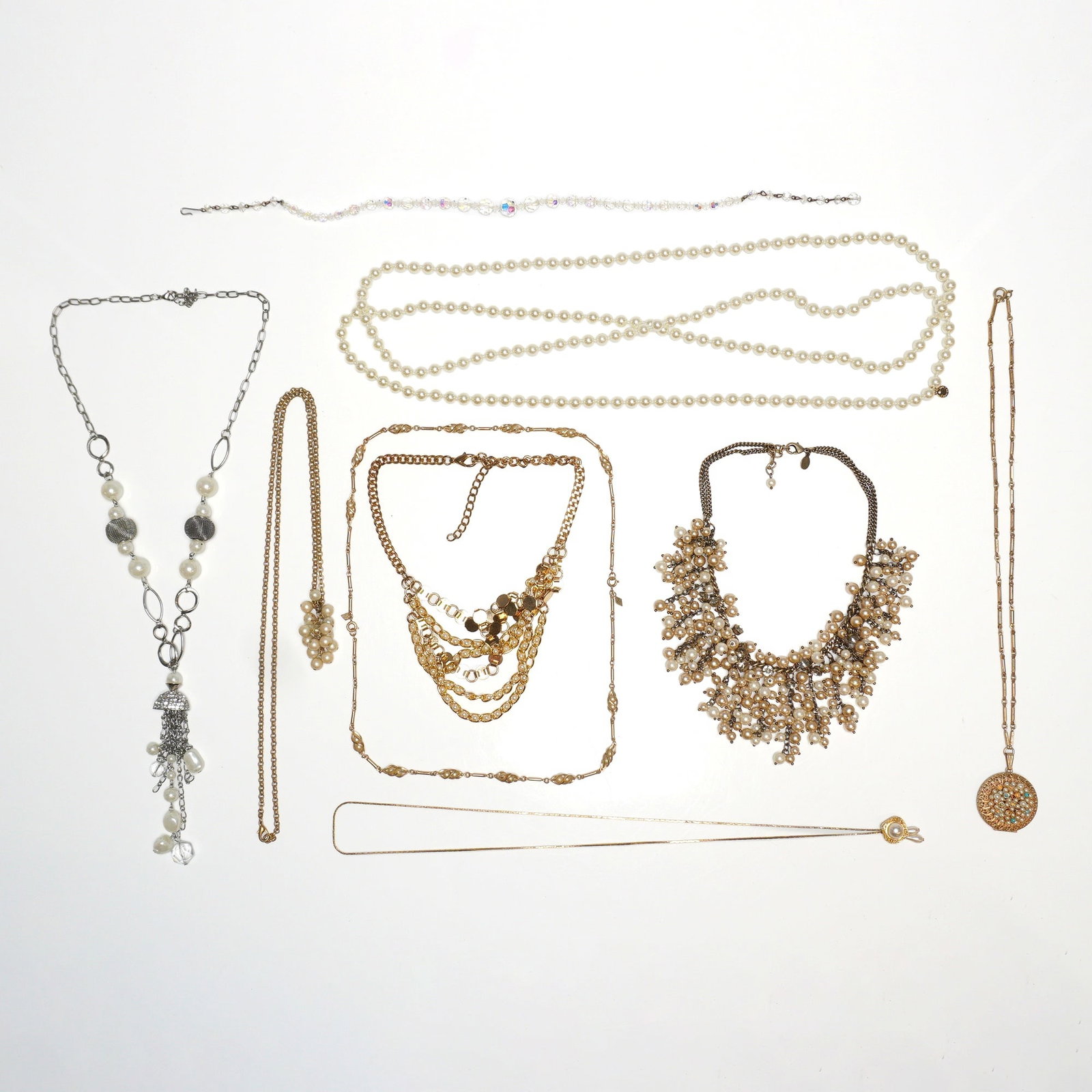 Gold and Silver-Tone Fashion Jewelry, Nine-Piece Necklace Lot, Faux Pearl and Rhinestone Accents: This 9pc glamorous necklace jewelry lot features a diverse collection of vintage-style costume pieces constructed from gold-tone and silver-tone base metals. The assortment includes a silver-tone tass