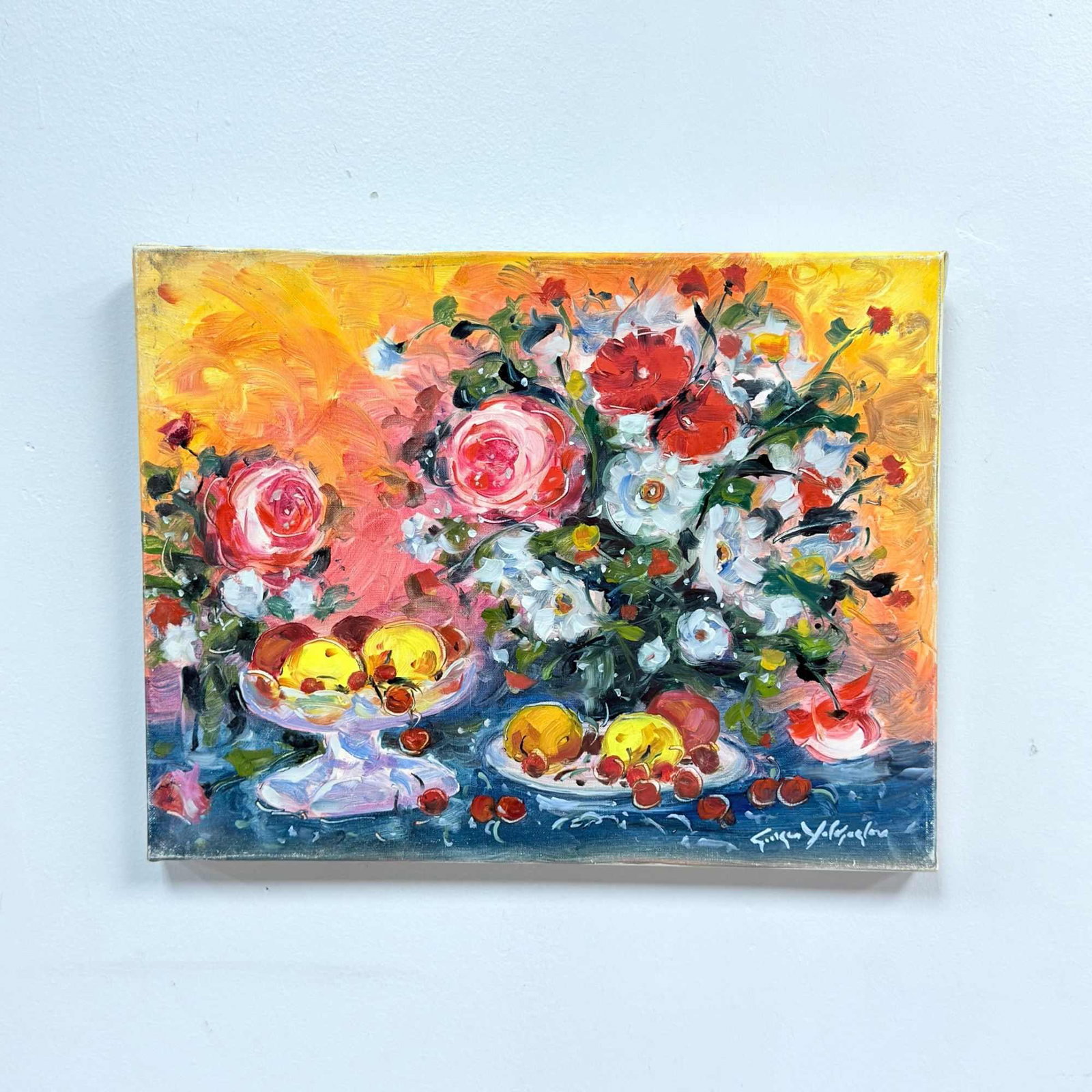 Georges Yoldjoglou (French, b. 1933), Fleurs et Fruits, Oil on Canvas: This work is an oil on canvas still life titled Fleurs et Fruits by the French artist Georges Yoldjoglou (born 1933). The painting depicts a lush arrangement of flowers and fruit. In the center, a lar