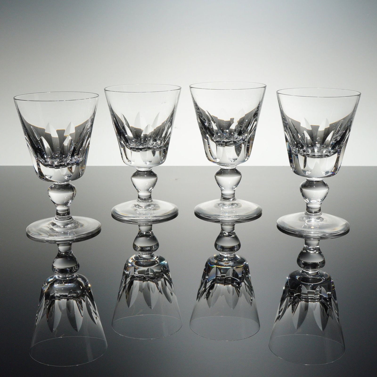 Set of 4 Saint-Louis Cut Crystal Wine Glasses, Jersey: A set of four exceptional heavy lead crystal stemmed glasses by the prestigious French glassmaker Saint-Louis, featuring the Jersey pattern. Each glass displays a rounded U-shaped bowl decorated with 