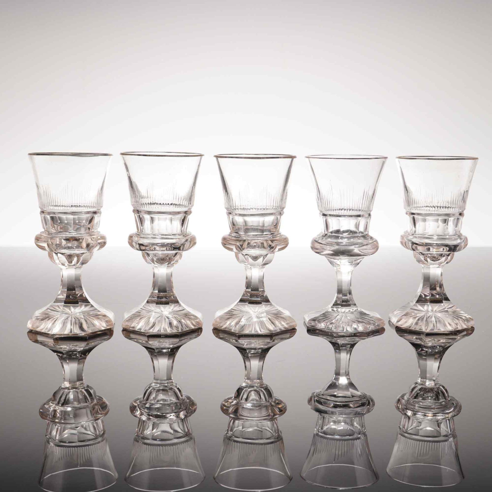5pc Reservoir Absinthe Glasses: This set of five glasses is crafted from clear lead crystal and follows the traditional French Pontarlier reservoir style, often used for serving absinthe. Each glass features a flared bowl with a ban
