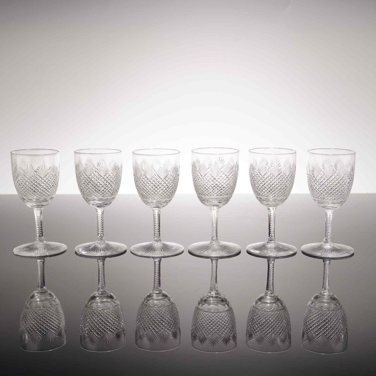 6pc American Brilliant Cut Crystal Sherry Glasses: A set of six lead crystal sherry glasses featuring the strawberry diamond and fan pattern. The bowl of each glass is decorated with a dense field of diamond-cut cross-hatching, surmounted by a series 